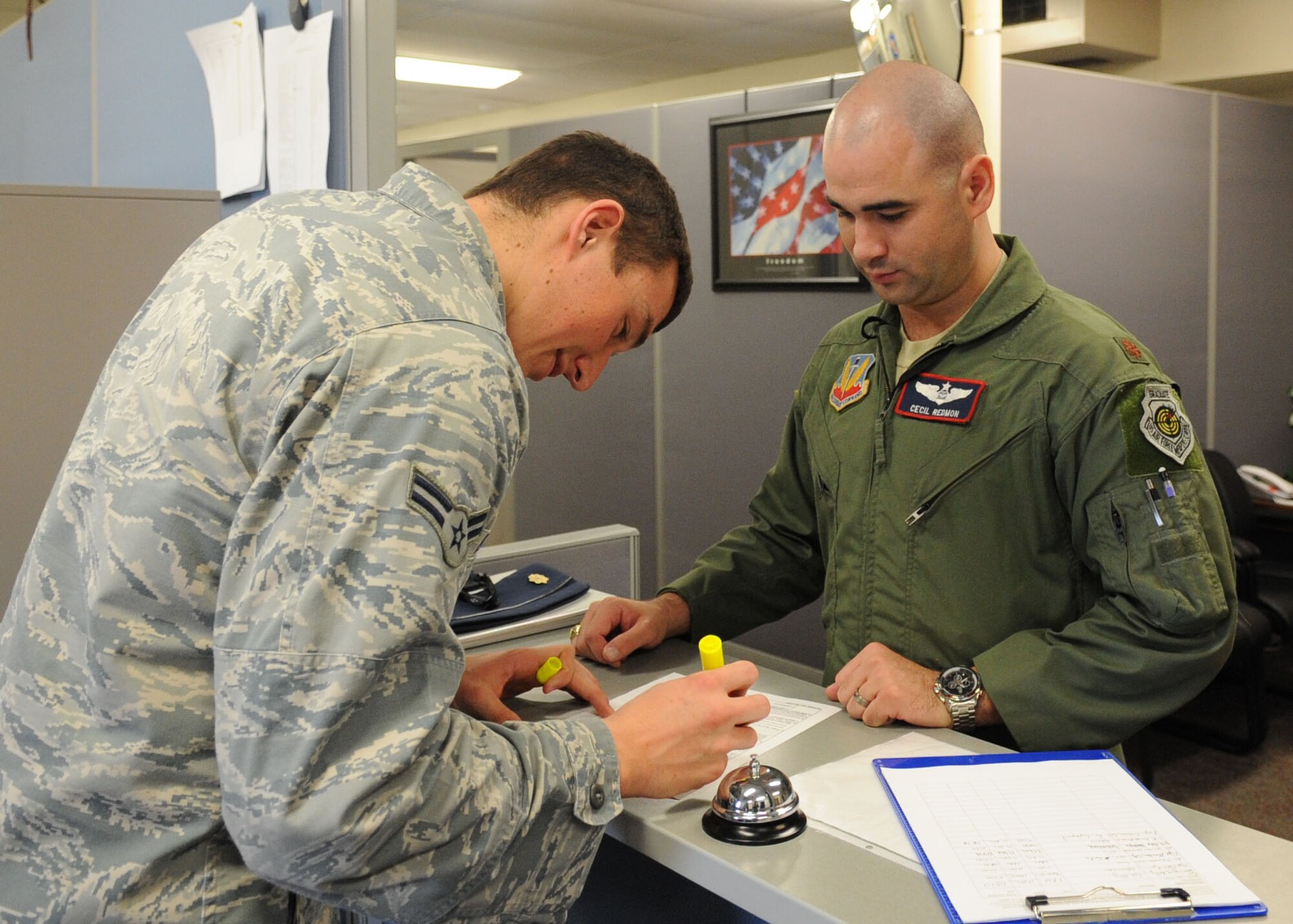 U.S. Air Force Airman 1st Class Alex Pennetti, left, 7th Comptroller Squadron financial technician, works with Maj. Cecil Redmon, 7th Operations Support Squadron, on deployment paperwork Dec. 19, 2013, at Dyess Air Force Base, Texas.  Pennetti is the wing agency program coordinator for the Government Travel Card program. The 7th CPTS was recently selected by Air Combat Command as the Maj. Gen Alfred K. Flowers Comptroller Squadron of the Year and the Financial Services Office of the Year award winner during the 2013 Financial Management and Comptroller Annual Awards. (U.S. Air Force photo by Senior Airman Shannon Hall/Released)