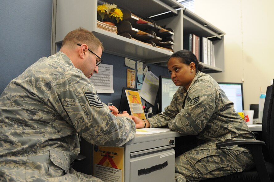 U.S. Air Force Tech. Sgt. Daniel Hallila, left, 7th Component Maintenance Squadron, is assisted by Senior Airman Jennifer Gill, 7th Comptroller Squadron financial support technician, with financial questions Dec. 19, 2013, at Dyess Air Force Base, Texas. Gill is part of the special actions team and handles separations, retirements, re-enlistments and leave sell back. For excelling in the Consolidated Unit Inspection of January 2013, securing $1 million for 19 civil engineering end-of-year projects and other mission impact achievements, the 7th CPTS was named the winner of the Maj. Gen. Alfred K. Flowers Comptroller Squadron of the Year award by Air Combat Command. The 7th Comptroller Squadron will compete at the Air Force level next. (U.S. Air Force photo by Senior Airman Shannon Hall/Released)