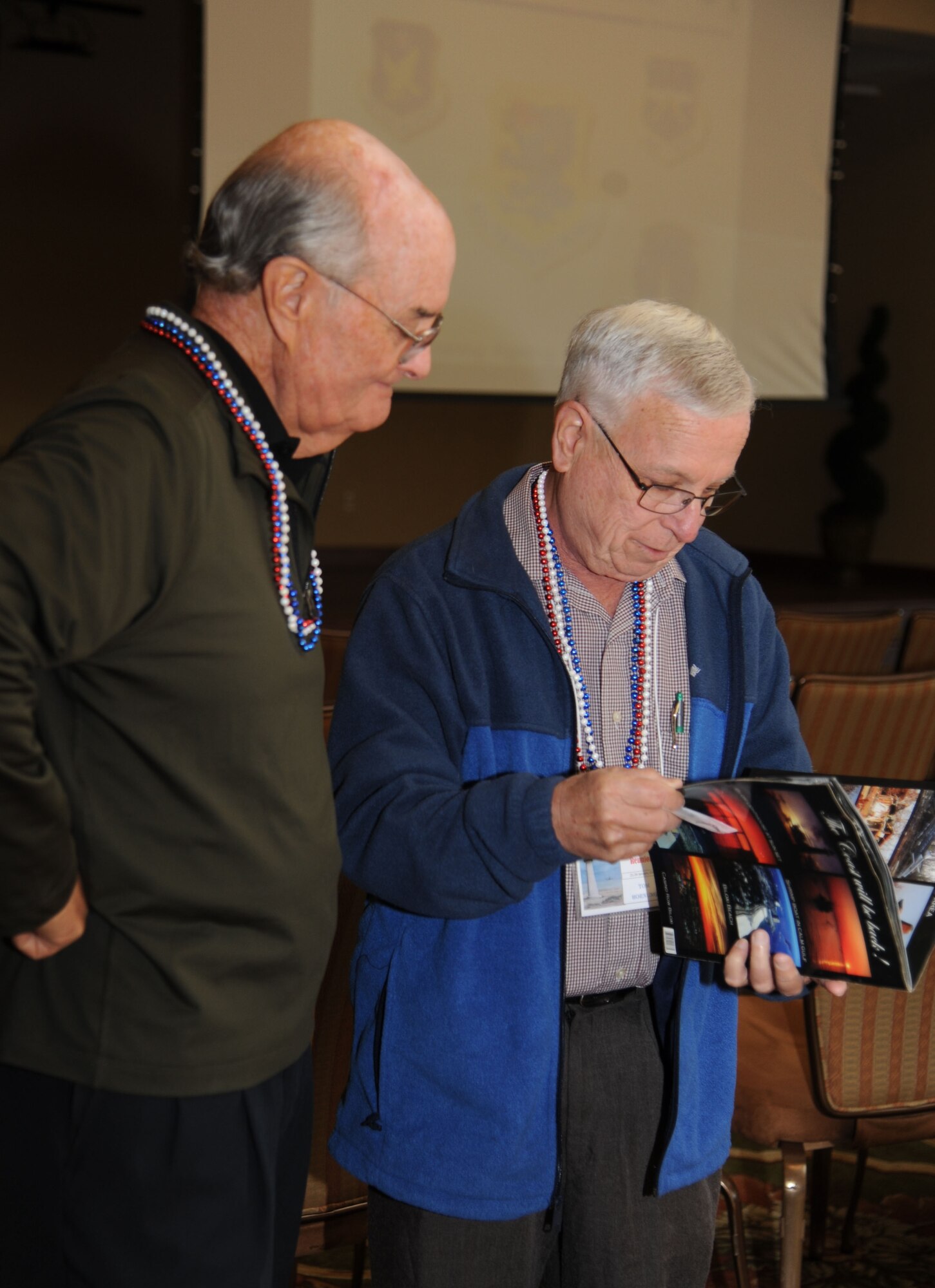 Retired Lt. Col. Ron Bailey, former Keesler Medical Readiness director, and retired Lt. Col. Tom Hornung, former Keesler Public Affairs chief, review a Hurricane Katrina book during a reunion of former Keesler leaders Jan. 22, 2014, at the Bay Breeze Event Center, Keesler Air Force Base, Miss.  The reunion included leaders who were assigned to Keesler during Hurricane Elena.  (U.S. Air Force photo by Kemberly Groue)