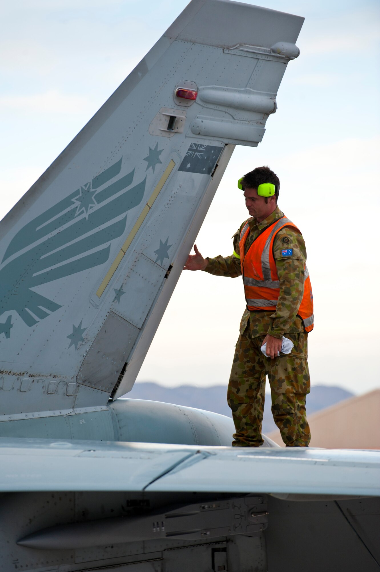 Royal Australian Air Force Lead Aircraftsman Josh Greiter, 77th Squadron, inspects the tail of an F/A-18 on the flightline Jan. 23, 2014, at Nellis Air Force Base, Nev. The RAAF, along with other allied nations, and the U.S. military will be participating in Red Flag 14-1. Red Flag is an opportunity for the U.S. and its allies to practice air-to-air combat scenarios and increase their overall combat readiness and efficiency. (U.S. Air Force photo by Airman 1st Class Thomas Spangler)