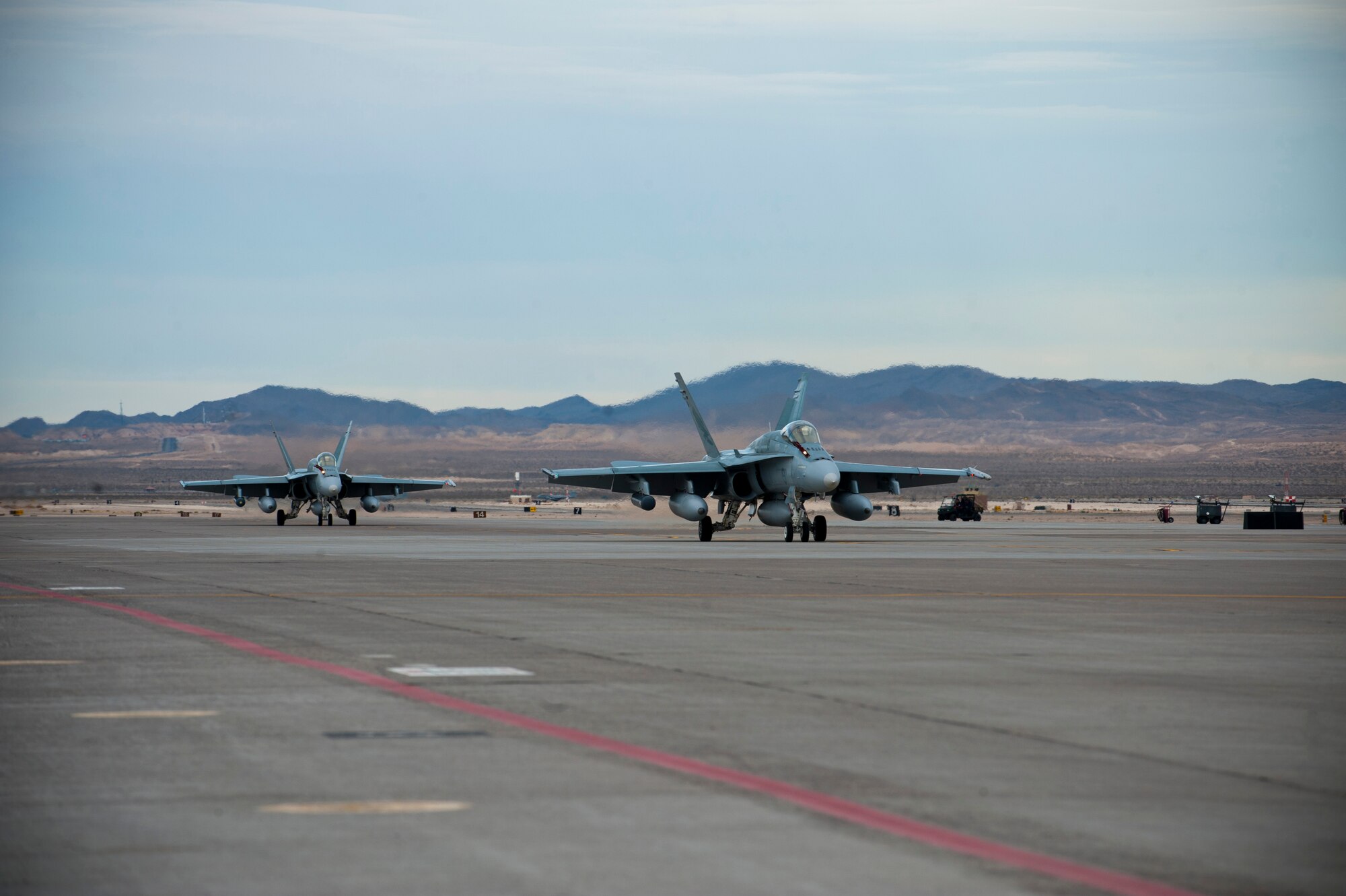 Two Royal Australian Air Force F/A-18s assigned to the 77th Squadron taxi along the flightline after landing Jan. 23, 2014, at Nellis Air Force Base, Nev. The RAAF, along with other allied nations’ air forces, and the U.S. military will be participating in Red Flag 14-1, a realistic training environment for air-to-air combat. (U.S. Air Force photo by Airman 1st Class Thomas Spangler)