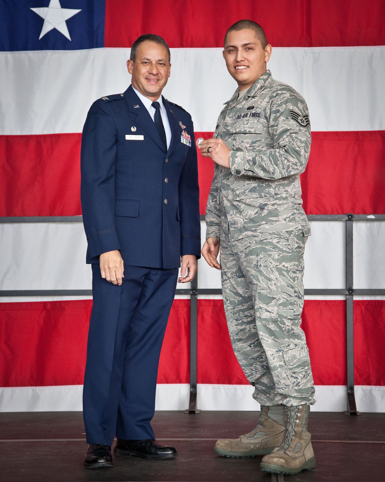 Col. Todd McCubbin, 934th Airlift Wing commander, recognizes Staff Sgt. Andrew Longtine with a commander's coin during the quarterly Wing Commander's Call at the Minneapolis-St. Paul Air Reserve Station, Minn.  Sergeant Longtine developed a 934 AW app for smartphones and tablets, the first of its kind in the Air Force Reserve Command and that provides intant access to important 934th information and interactive sites. (U.S. Air Force photo by Shannon McKay/Released)
