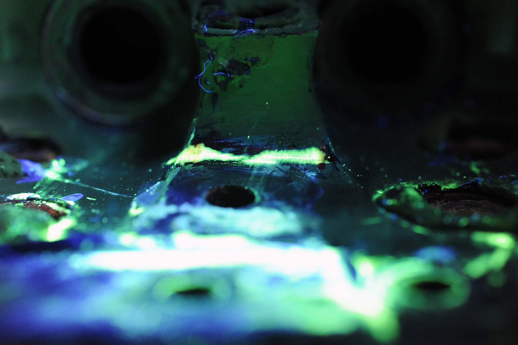 A crack in an F-16 Fighting Falcon wing attachment fitting is filled with dye penetrant and placed under a black light for inspection. This method of inspection keeps the structural integrity of the aircraft components without impairing their future functionality. (U.S. Air Force photo/Airman 1st Class Pedro Mota