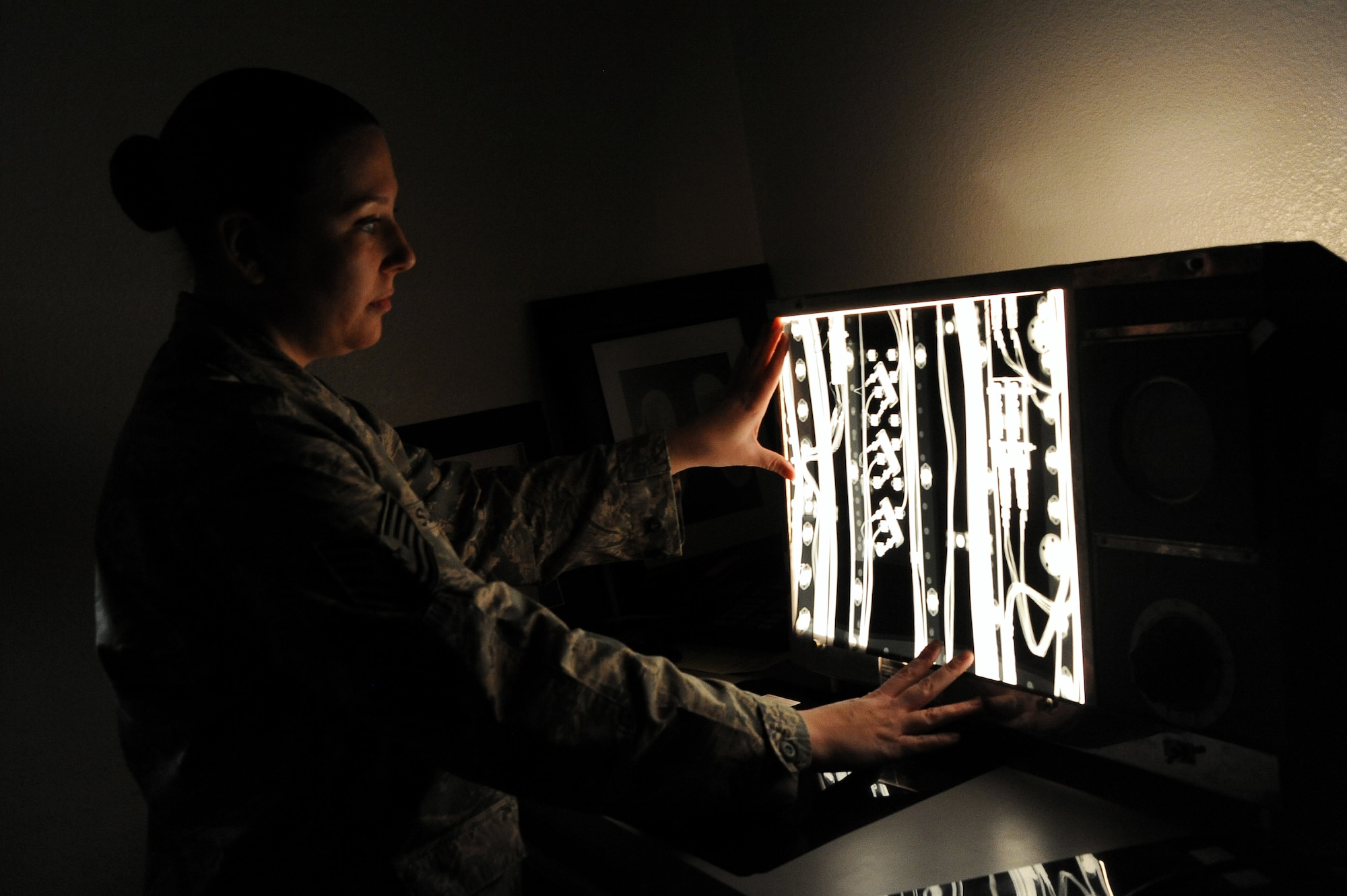 Tech. Sgt. Erika Vasquez, 56th Equipment Maintenance Squadron nondestructive inspection section chief, views a radiograph of an internal component of the F-16 Fighting Falcon. The light behind the X-ray helps technicians identify erosion, cracks or defects in components. (U.S. Air Force photo/Airman 1st Class Pedro Mota