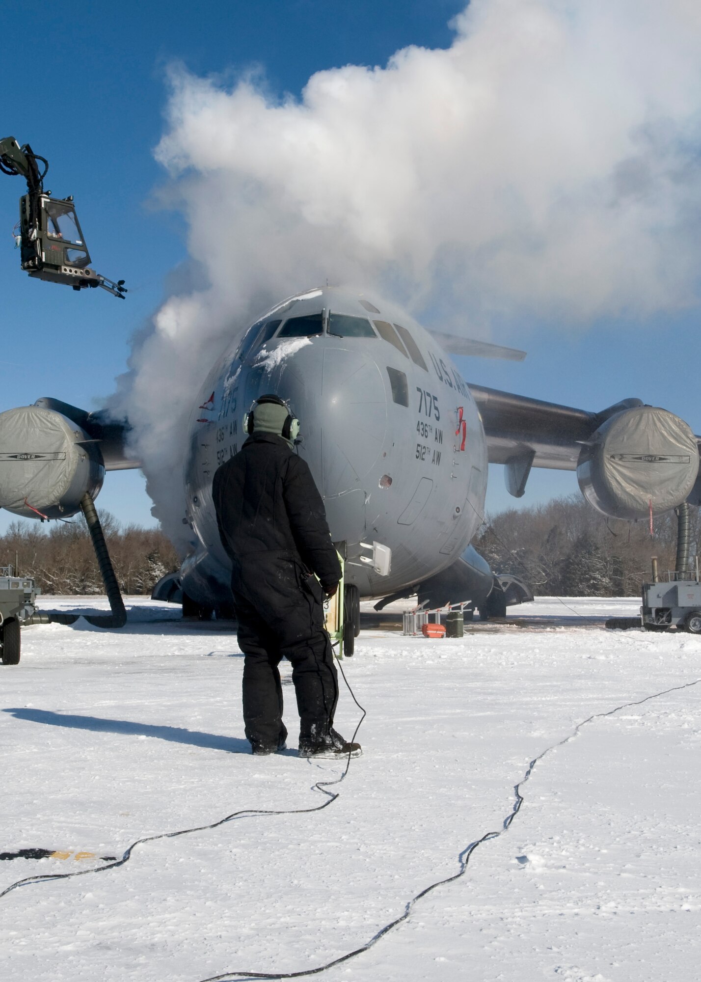 Senior Airman Houson Nielson, 736th Aircraft Maintenance Squadron crew chief, watches as a C-17 Globemaster III is deiced in preparation for a mission Jan. 22, 2014, at Dover Air Force Base, Del. The deicing process removes ice and snow from the aircraft’s body in order to make it flight-ready. (U.S. Air Force photo/Airman 1st Class Zachary Cacicia)