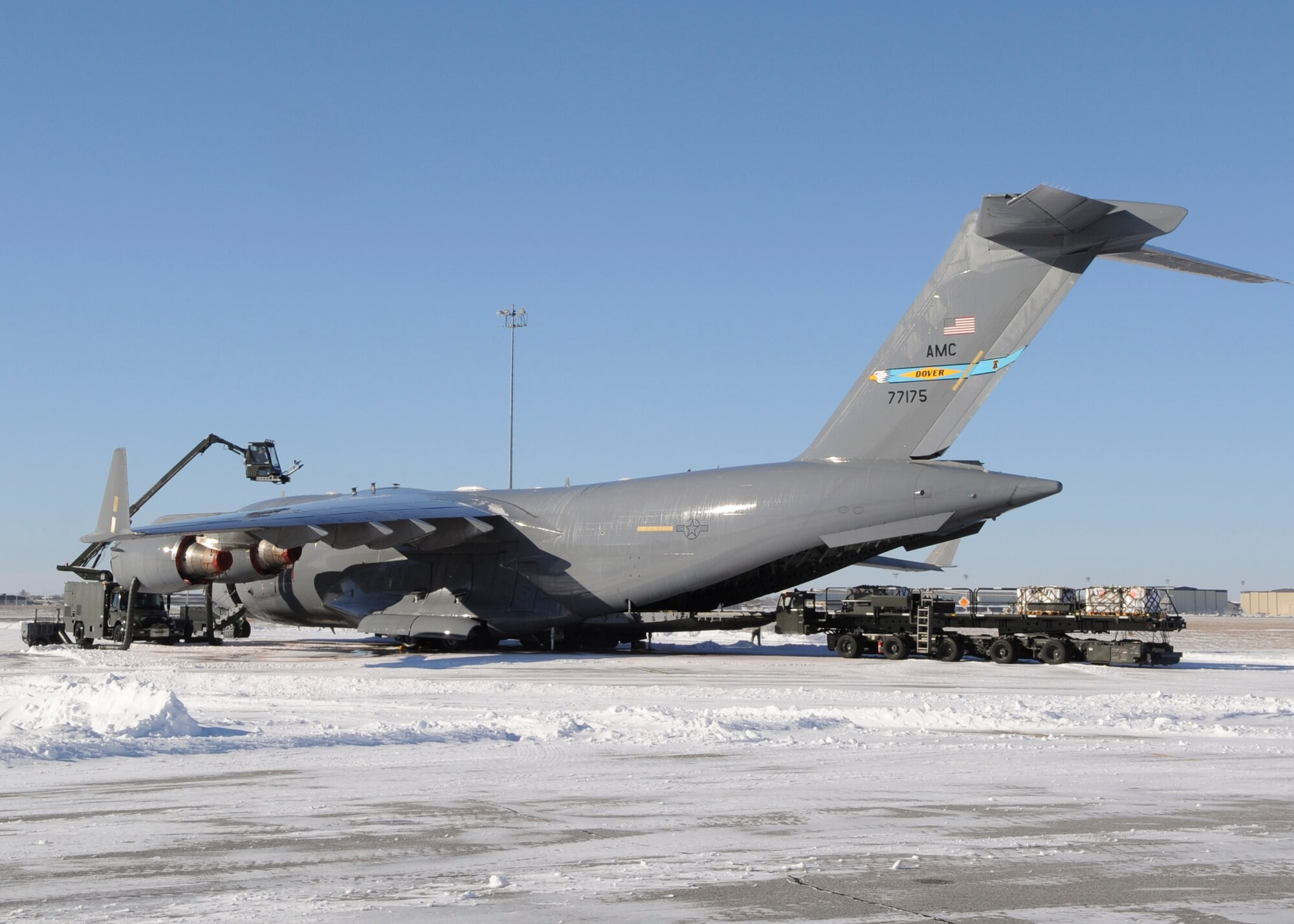 Members of the 736th Aircraft Maintenance Squadron deice a C-17 Globemaster III, while it is being loaded in preparation for a mission Jan. 22, 2014, at Dover Air Force Base, Del. Deicing fluid is sprayed onto the aircraft in order to remove ice and snow from the previous night’s snowstorm. (U.S. Air Force photo/Airman 1st Class Zachary Cacicia)