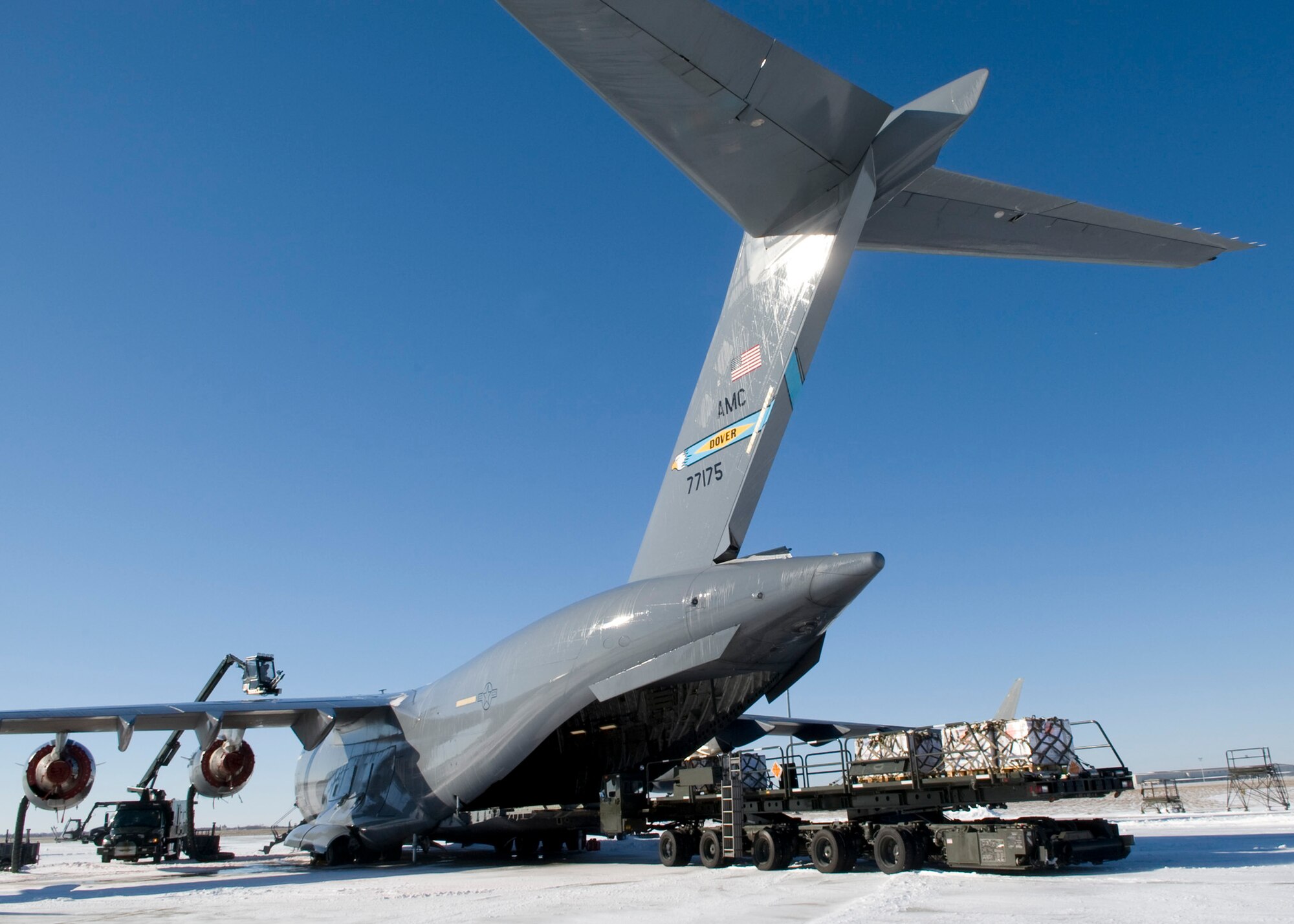 Members of the 736th Aircraft Maintenance Squadron deice a C-17 Globemaster III, while it is being loaded in preparation for a mission Jan. 22, 2014, at Dover Air Force Base, Del. Six inches of snow fell at Dover the previous night. (U.S. Air Force photo/Airman 1st Class Zachary Cacicia)