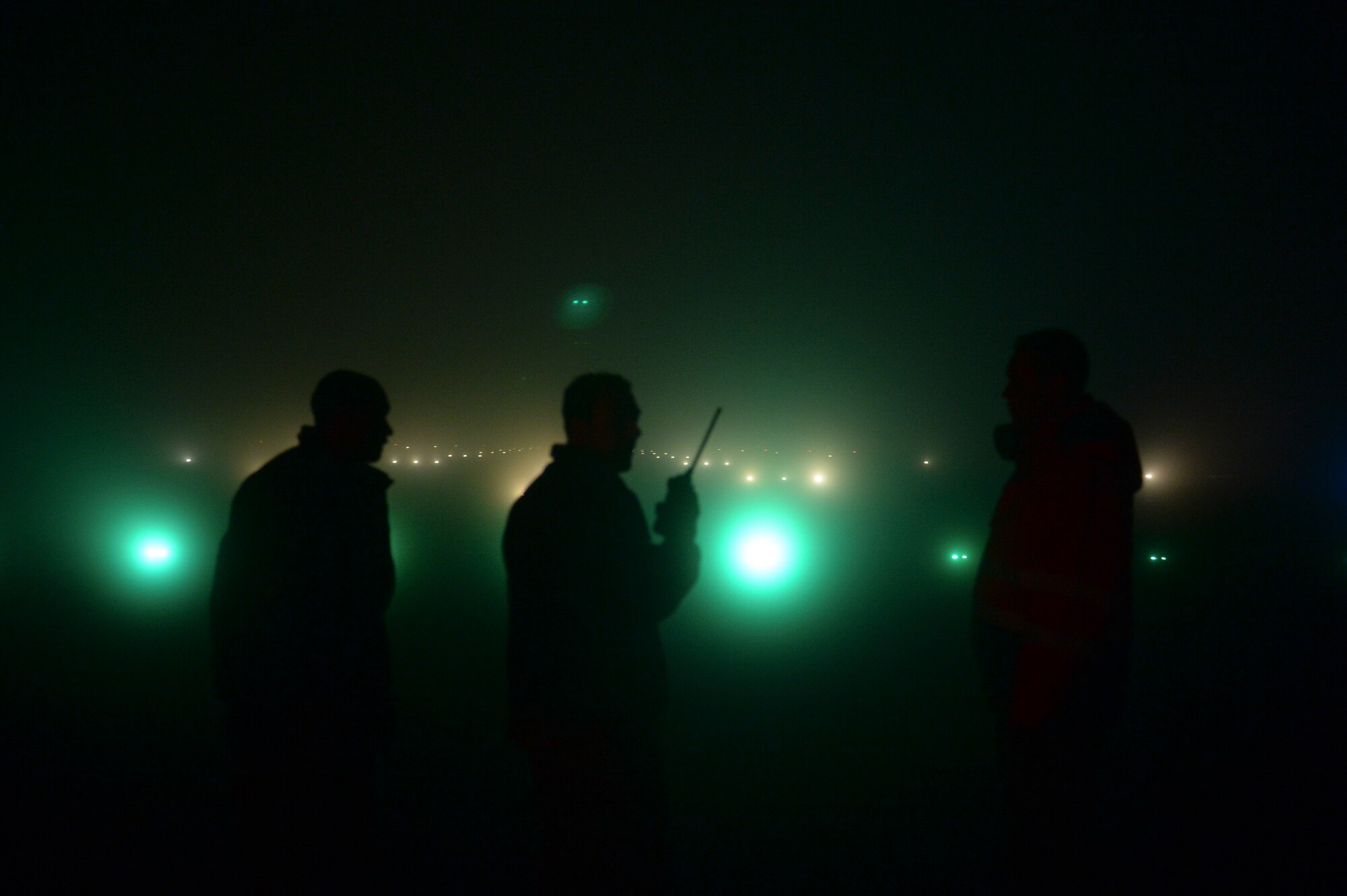 Members of the 52nd Civil Engineer Squadron observe as lights activate during a check of the airfield lighting system at Spangdahlem Air Base, Germany, Jan. 23, 2014. Members of the 52nd CES's airfield lighting check more than 3,000 lights on the airfield every day. (U.S. Air Force photo by Senior Airman Rusty Frank / Released)