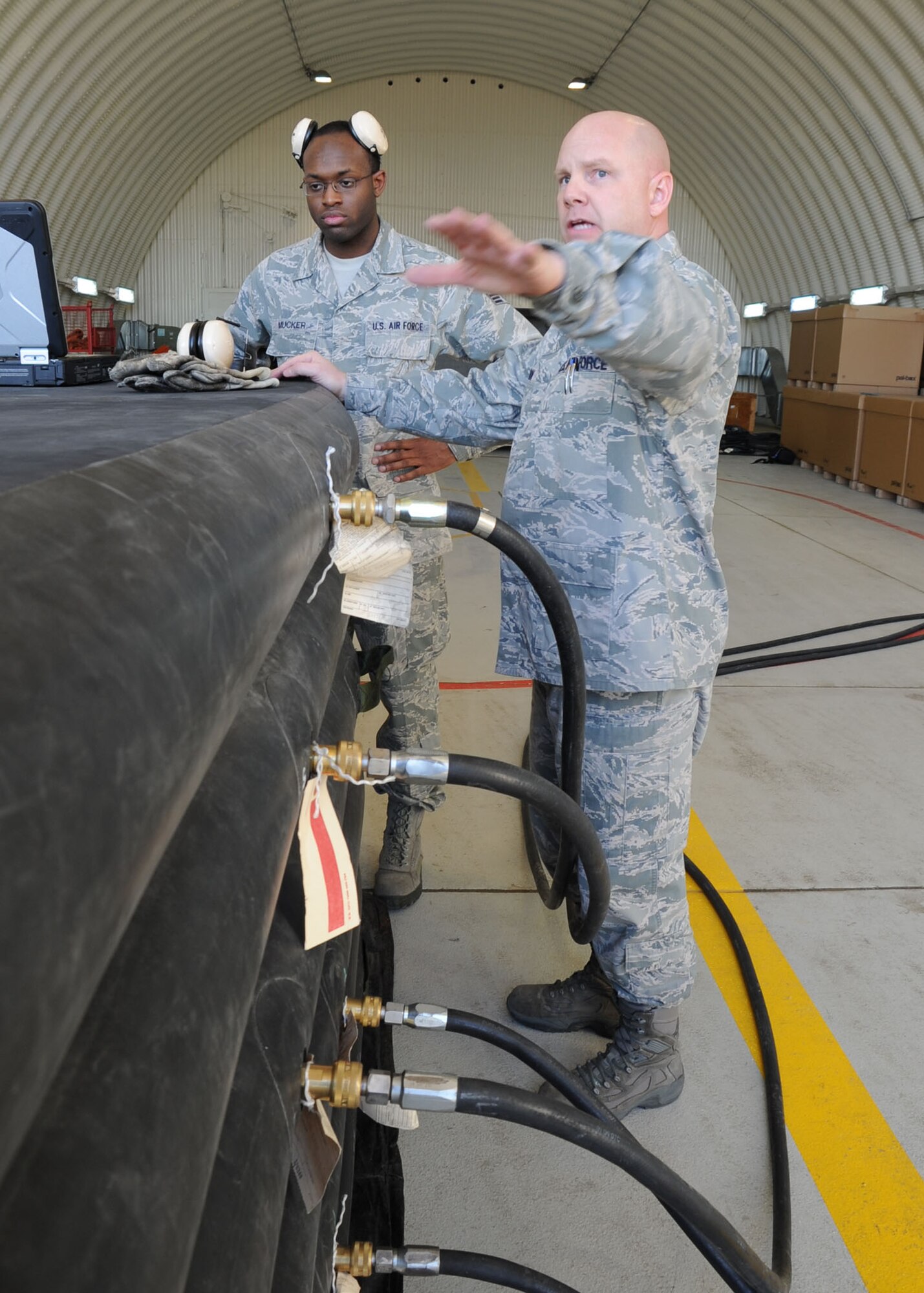 Tech. Sgt. Robert Jackson 39th Maintenance Squadron, Crash Disabled Damaged Aircraft Recovery team chief explains the capabilities of the pneumatic airbag to Col. Craig Wills, 39th Air Base Wing commander, and Chief Master Sgt. Anthony Johnson, 39th ABW command chief, Jan. 23, 2014, at Incirlik Air Base, Turkey.  The team demonstrated of the squadrons Crash Disabled Damaged Aircraft Recovery capability. The air-bag technique is a last resort process, which provides lift capabilities in the event of a damaged aircraft. The CDDAR team maintains the training and knowledge to safely lift a damaged airframe. (U.S. Air Force photo by Staff Sgt. Veronica Pierce/Released)