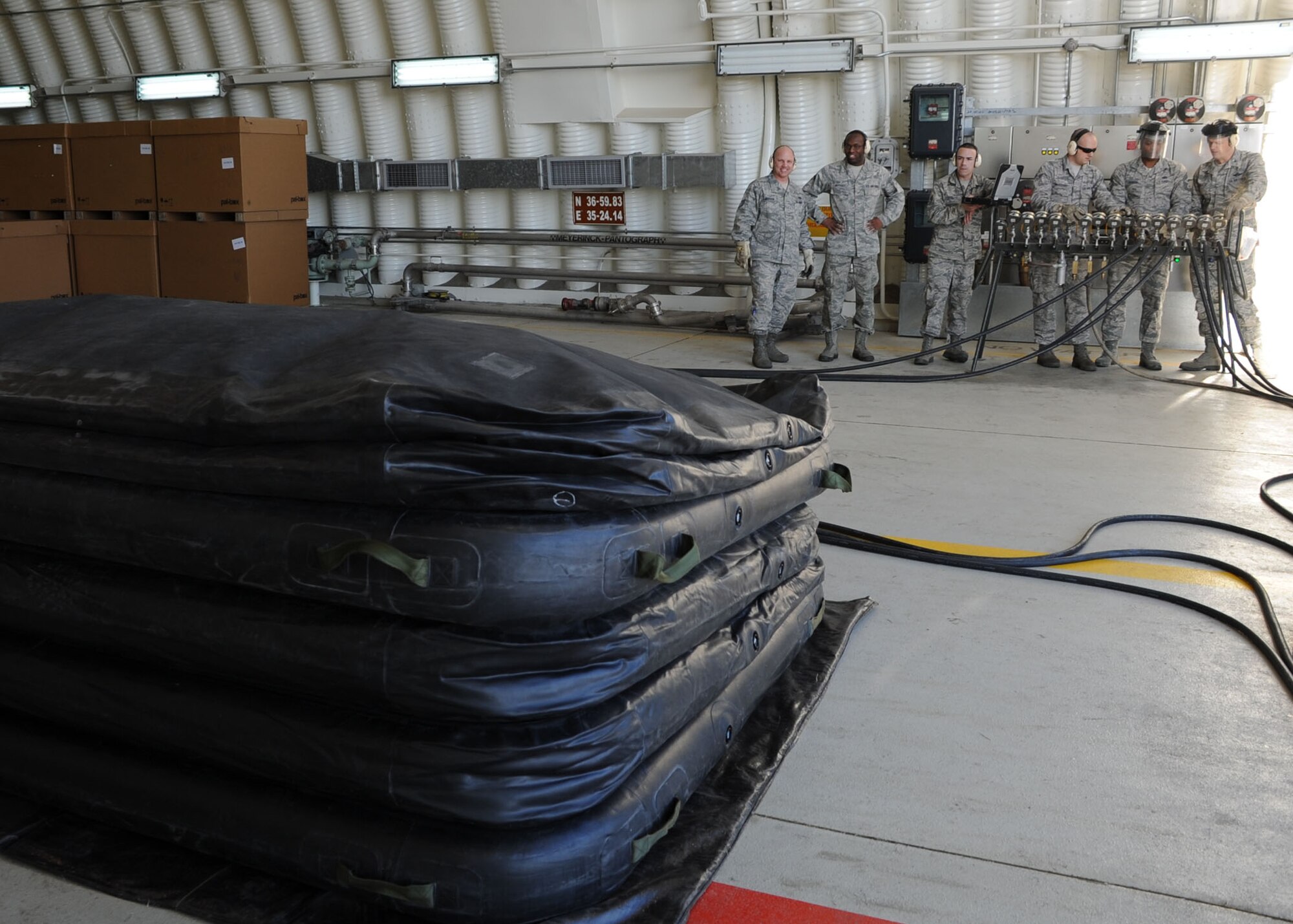 Col. Craig Wills, 39th Air Base Wing commander, and Chief Master Sgt. Anthony Johnson, 39th ABW command chief, along with Airmen from the 39th Maintenance Squadron watch as a pneumatic airbag inflates Jan. 23, 2014, at Incirlik Air Base, Turkey.  The team demonstrated of the squadrons Crash Disabled Damaged Aircraft Recovery capability. The airbag technique is a last resort process, which provides lift capabilities in the event of a damaged aircraft. The CDDAR team maintains the training and knowledge to safely lift a damaged airframe. (U.S. Air Force photo by Staff Sgt. Veronica Pierce/Released)