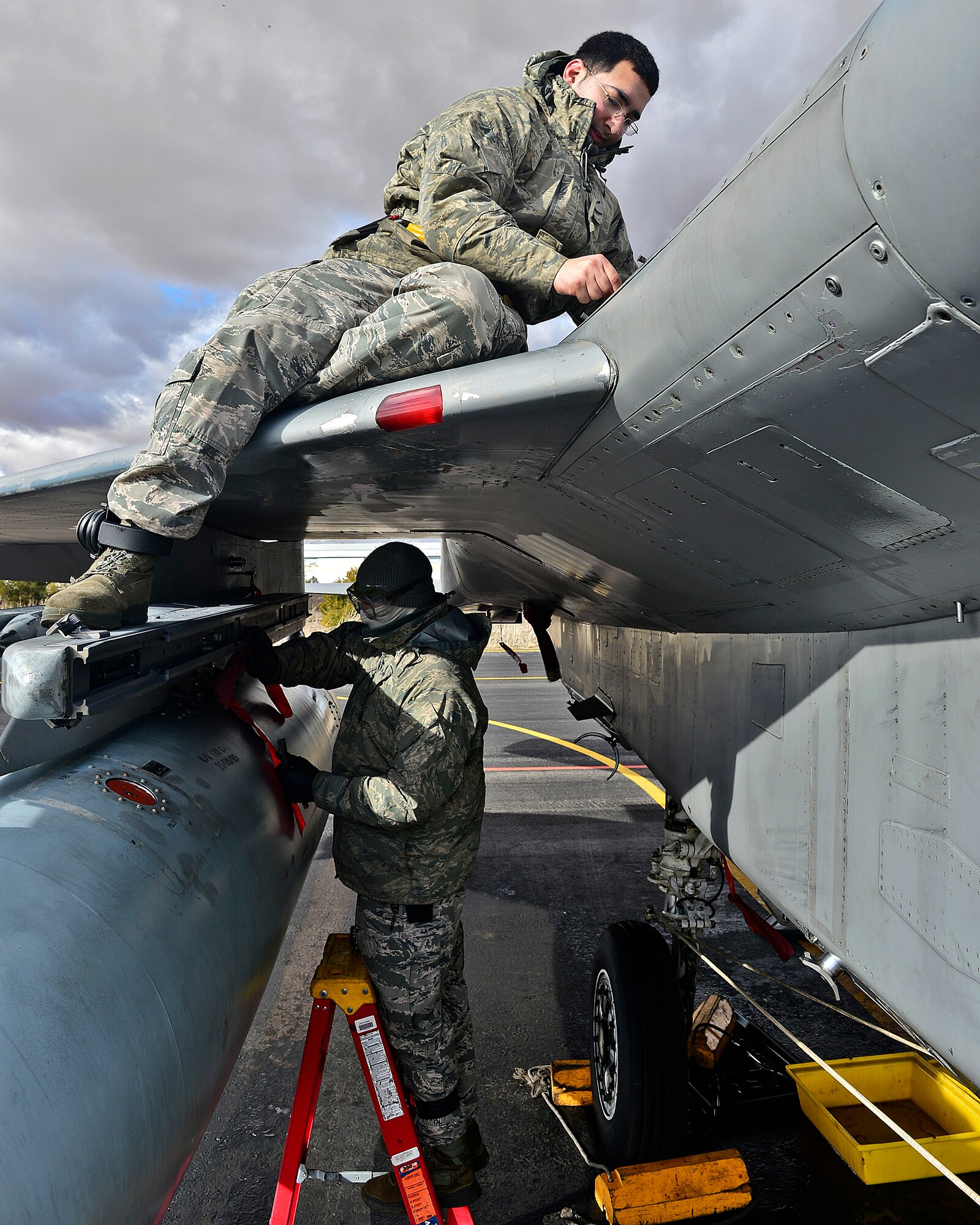 Airman 1st Class Hipjunior Cruz (Top) and Senior Airman Robert Peniowich, 748th Aircraft Maintenance Squadron  weapons load crew members, perform a scheduled weapons maintenance inspection on an F-15C Eagle during Tactical Leadership Program  at Albacete  Air Base, Spain, Jan. 20,2014. The 493rd Fighter Squadron from Royal Air Force Lakenheath, England is participating in the multi-national program, which develops key leadership and mission-planning skills needed for NATO operations. (U.S. Air Force photo by Staff Sgt. Stephanie Mancha/Released)
