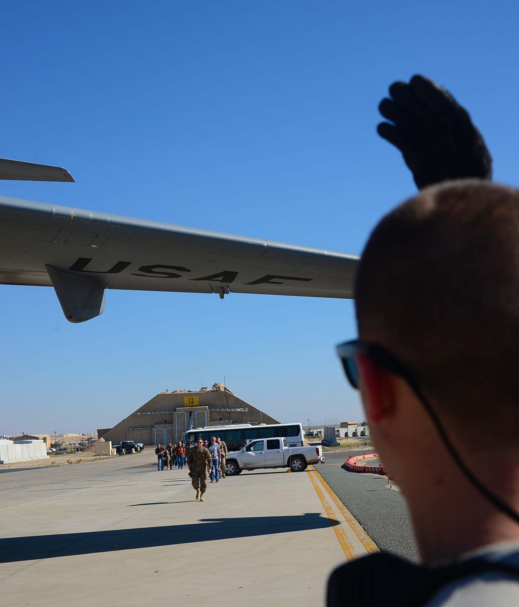 Staff Sgt. Ben Woods, 386th Expeditionary Logistics Readiness Squadron air transportation operations, directs military personnel boarding a C-17 Globemaster III destined for Bagram Air Field, Afghanistan, at an undisclosed location in Southwest Asia. Forward deployments are one of the daily operations on the flight line. (U.S. Air Force photo by Senior Airman Desiree W. Moye)