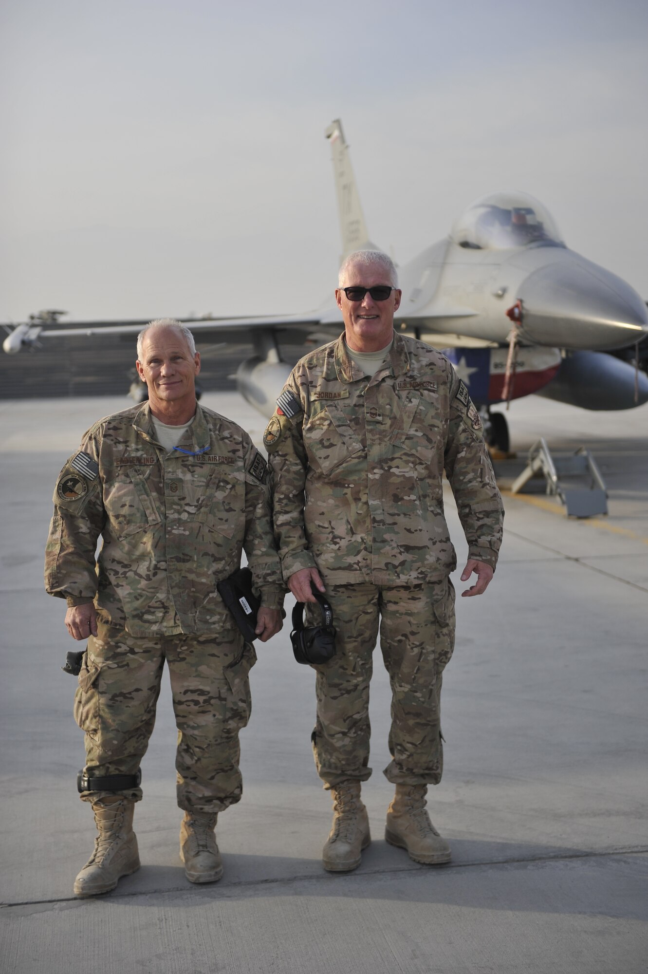 U.S. Air Force Master Sgt. Doyle Easterling and Senior Master Sgt. Paul Jordan stand together in front of an F-16 Fighting Falcon after a successful engine test run at Bagram Airfield, Afghanistan, Jan. 20, 2014. Both are deployed out of Carswell Joint Reserve Base in Fort Worth, Texas to Bagram, and will be retiring this year after a combined 78 years of military service. (U.S. Air Force photo by Senior Master Sgt. Gary J. Rihn/Released)