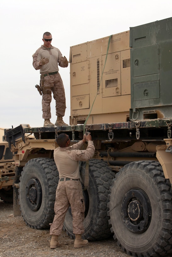 U.S. Marines strap down generators onto a flatbed truck on Forward Operating Base Delaram, Afghanistan, Jan. 16, 2014.