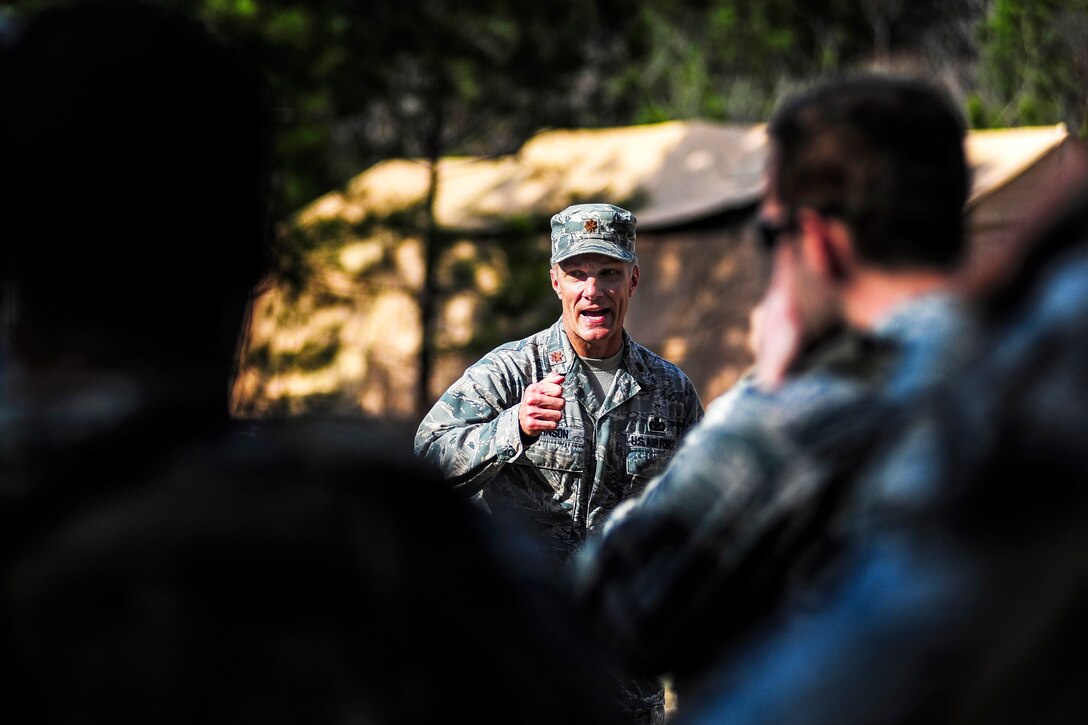 Air Force Maj. Michael Johnson, center, speaks to airmen about the importance of the course they will take on the ability to survive and operate on North Auxiliary Airfield, S.C., Jan. 14, 2014. Johnson commands the 1st Combat Camera Squadron, which hosted the weeklong course.