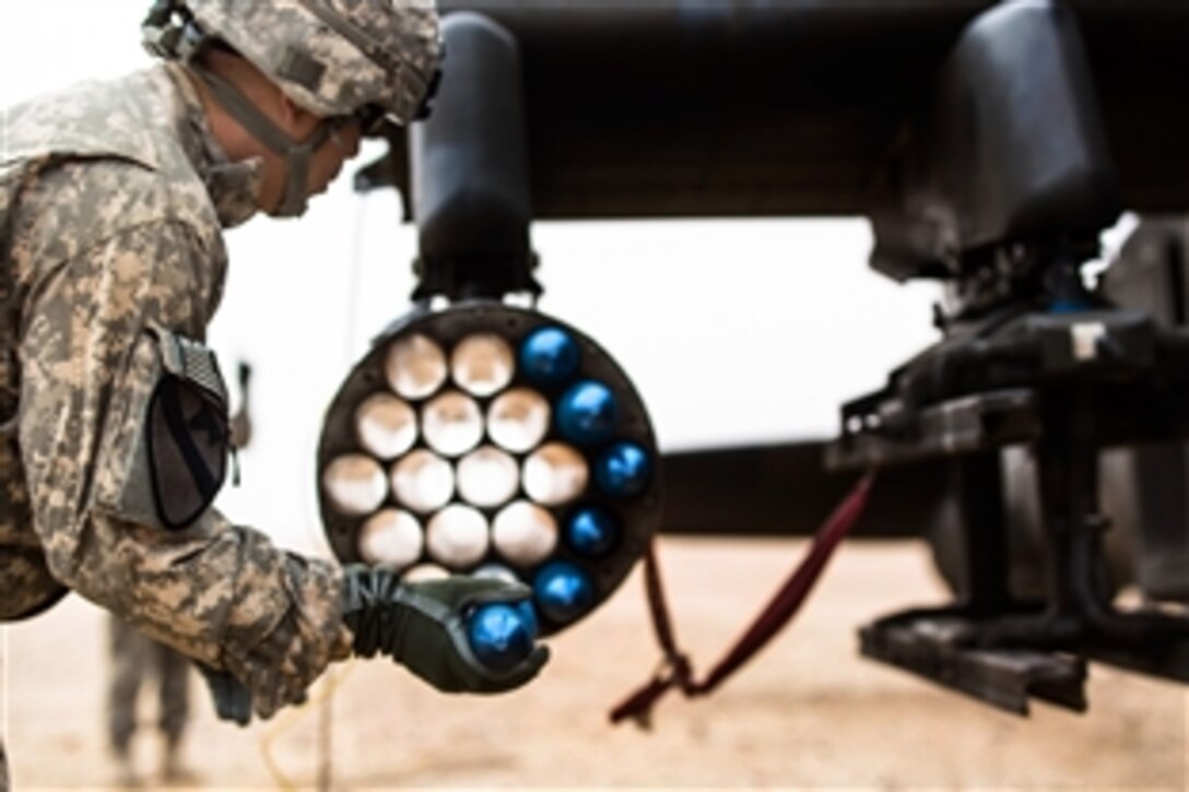 U.S. soldiers load an AH-64 Apache helicopter with rockets during a forward arming and refueling point exercise near Camp Buehring, Kuwait, Jan. 15, 2014.