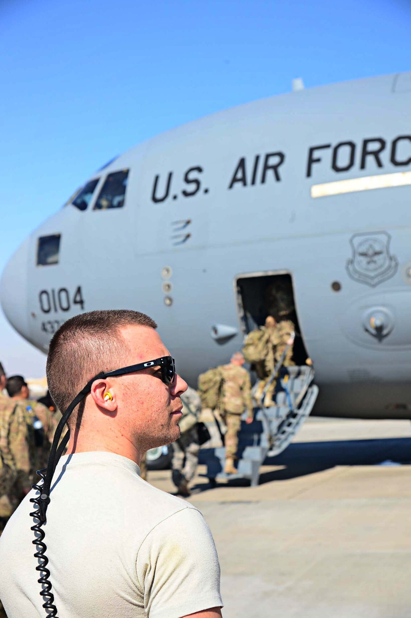 Staff Sgt. Ben Woods, 386th Expeditionary Logistics Readiness Squadron air transportation operations, directs military personnel boarding a C-17 Globemaster III destined for Bagram Air Field, Afghanistan, at an undisclosed location in Southwest Asia. Forward deployments are one of the daily operations on the flight line. (U.S. Air Force photo by Senior Airman Desiree W. Moye)