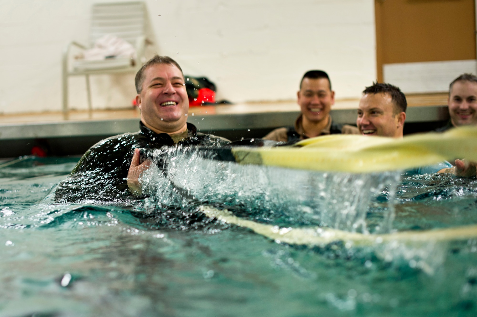 An Airman from the 133rd Operations Group is pulled through the water by airman from the 109th Airlift Squadron to simulate a parachute drag during water survival training at Foss Swim School in Eden Prairie, Minn., Jan 24, 2014. Water survival training encompasses equipment familiarization and processes in the event of an emergency over-water ditching scenario. (U.S. Air National Guard photo by Staff Sgt. Austen Adriaens/Released)