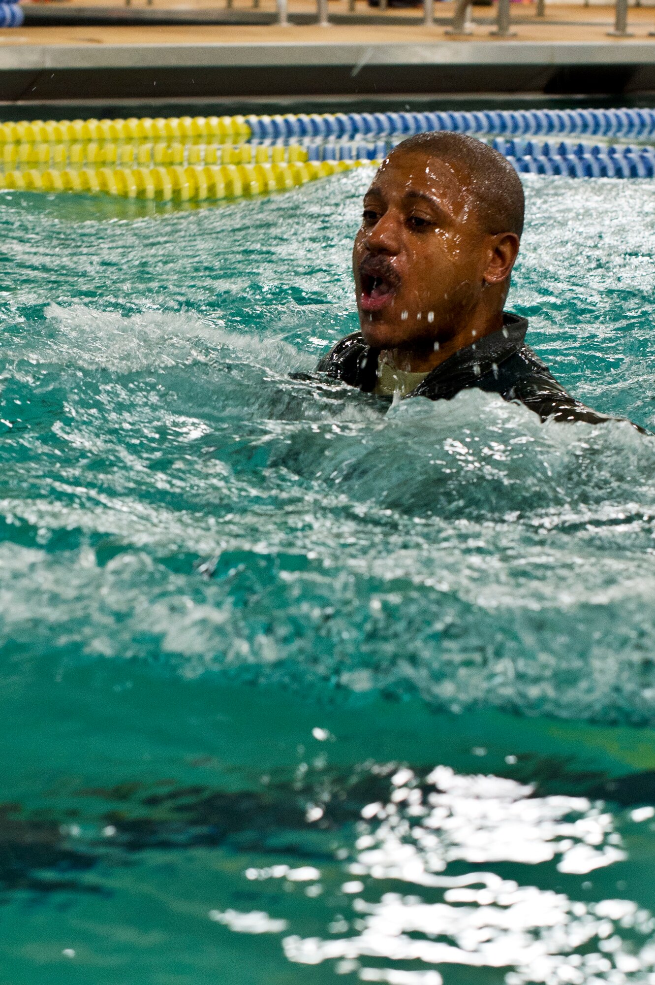 Master Sgt. Robben Todd, 109th Airlift Squadron, emerges from the water after a simulated parachute drag during water survival training at Foss Swim School in Eden Prairie, Minn., Jan 24, 2014. Water survival training encompasses equipment familiarization and processes in the event of an emergency over-water ditching scenario. (U.S. Air National Guard photo by Staff Sgt. Austen Adriaens/Released)