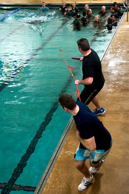 Staff Sgt. Jake Bonniwell, front, and Tech. Sgt. Adam Wasieleski, back, pull aircrew members of the 133rd Operations Group through the water to simulate a parachute drag during water survival training at Foss Swim School in Eden Prairie, Minn., Jan 24, 2014. Water survival training encompasses equipment familiarization and processes in the event of an emergency over-water ditching scenario. (U.S. Air National Guard photo by Staff Sgt. Austen Adriaens/Released)