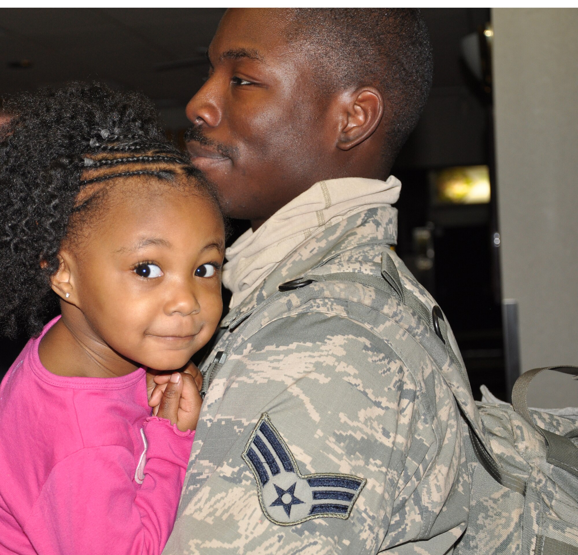 Senior Airman Tadriaun Logan, a security forces Airman from the 931st Security Forces Squadron, 931st Air Refueling Group holds his daughter, Ze'Kaiyah at the Wichita Mid-Continent Airport. Logan was among ten 931st SFS Airmen who returned from a four-month deployment to the Transit Center at Manas, Jan. 25. (Air Force photo by Master Sgt. Brannen Parrish)