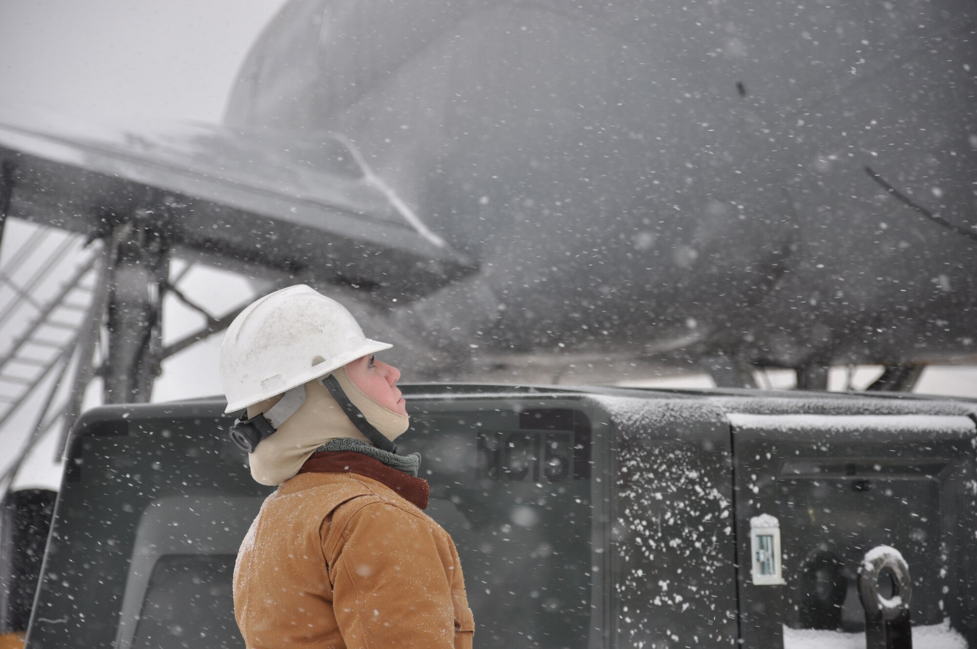 Senior Airman Diana Getting of the 714th Aircraft Maintenance Squadron monitors the progress of engine cover installation on a KC-10 Extender amid high winds and feathery snowflakes during snow removal efforts here Jan. 25 on the flightline (U.S. Air Force photo/Tech Sgt. Jonathan White). 