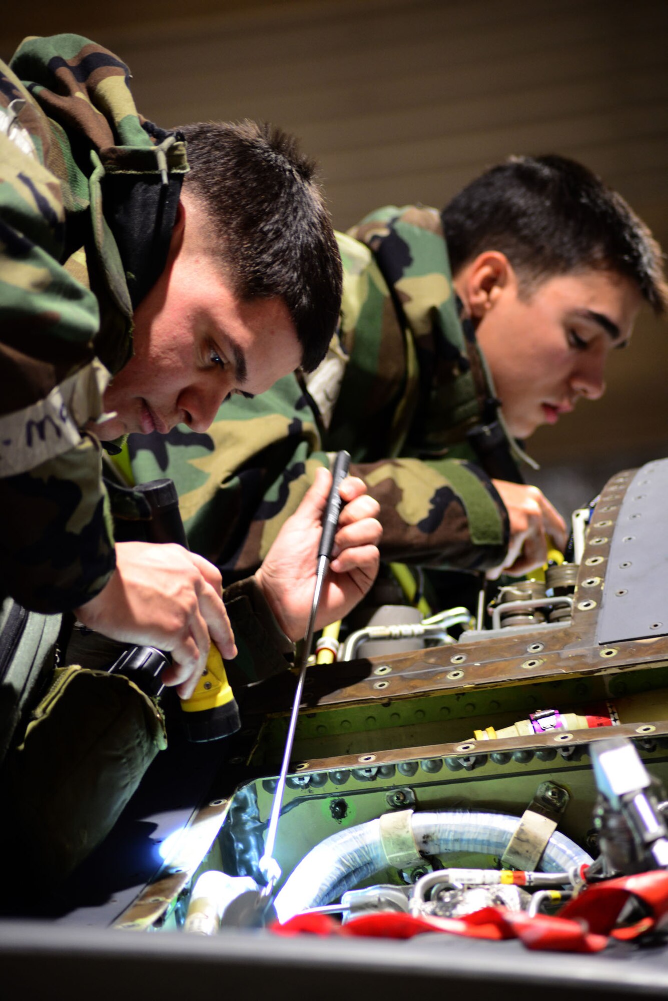 U.S. Air Force Airman 1st Class Ryan Scavuzzo, 35th Maintenance Squadron crew chief/phase inspection section team member, checks to make sure the hydraulic filter on an F-16 Fighting Falcon and the safety wire was attached, securing the filter in place during an operational readiness exercise on Misawa Air Base, Japan, Jan. 27, 2014. The phase inspection team looks over every inch of the jet and reports/repairs any faulty equipment. (U.S. Air Force photo/Tech. Sgt. April Quintanilla)