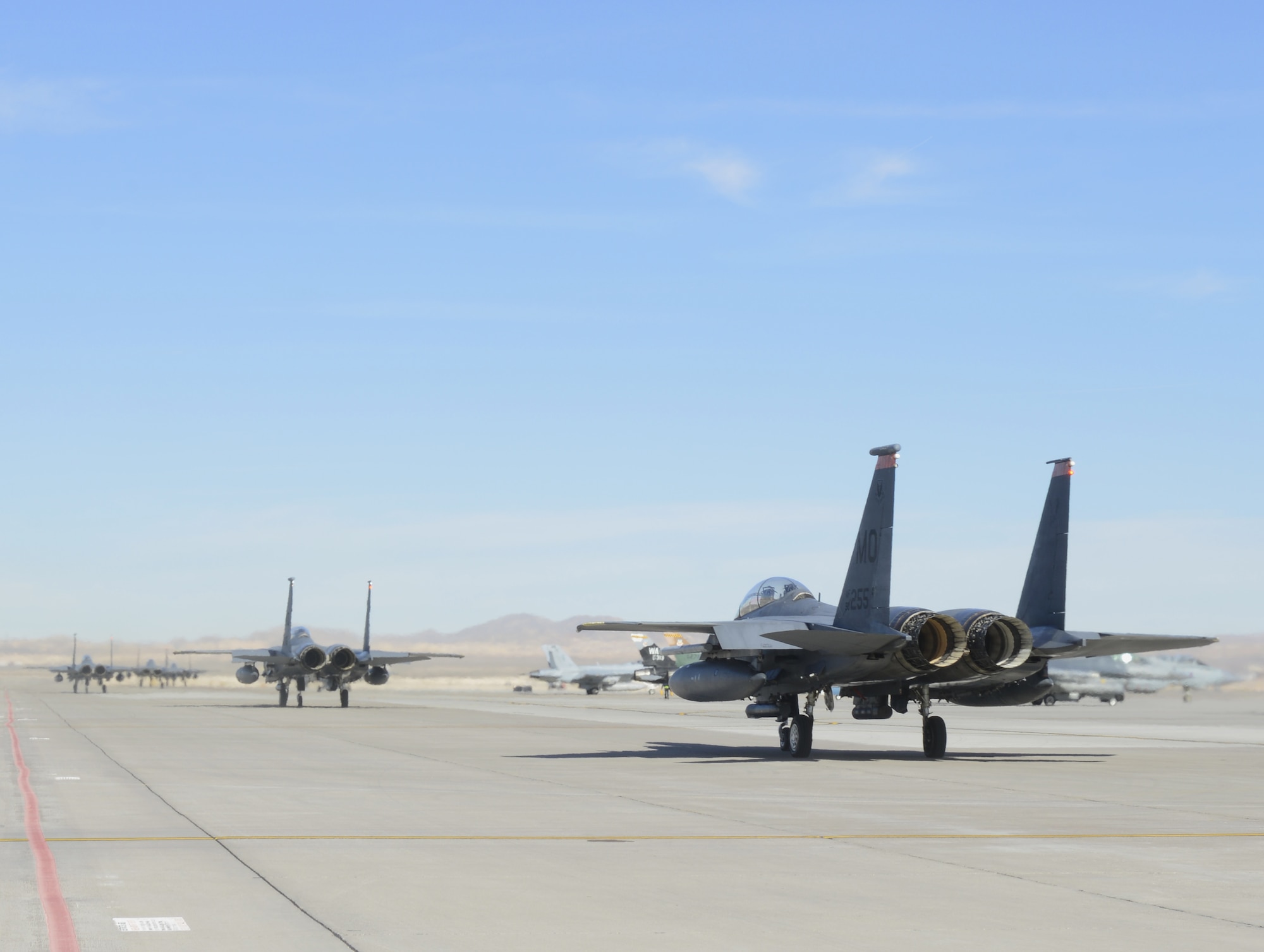 Multiple F-15E Strike Eagles taxi along the flightline Jan. 26, 2014, at Nellis Air Force Base, Nevada. The squadron is participating in the combat  training exercise Red Flag 14-1.The purpose of the exercise is to increase the combat capability of U.S. and allied air forces for future combat situations. (U.S. Air Force photo by Senior Airman Benjamin Sutton/Released)