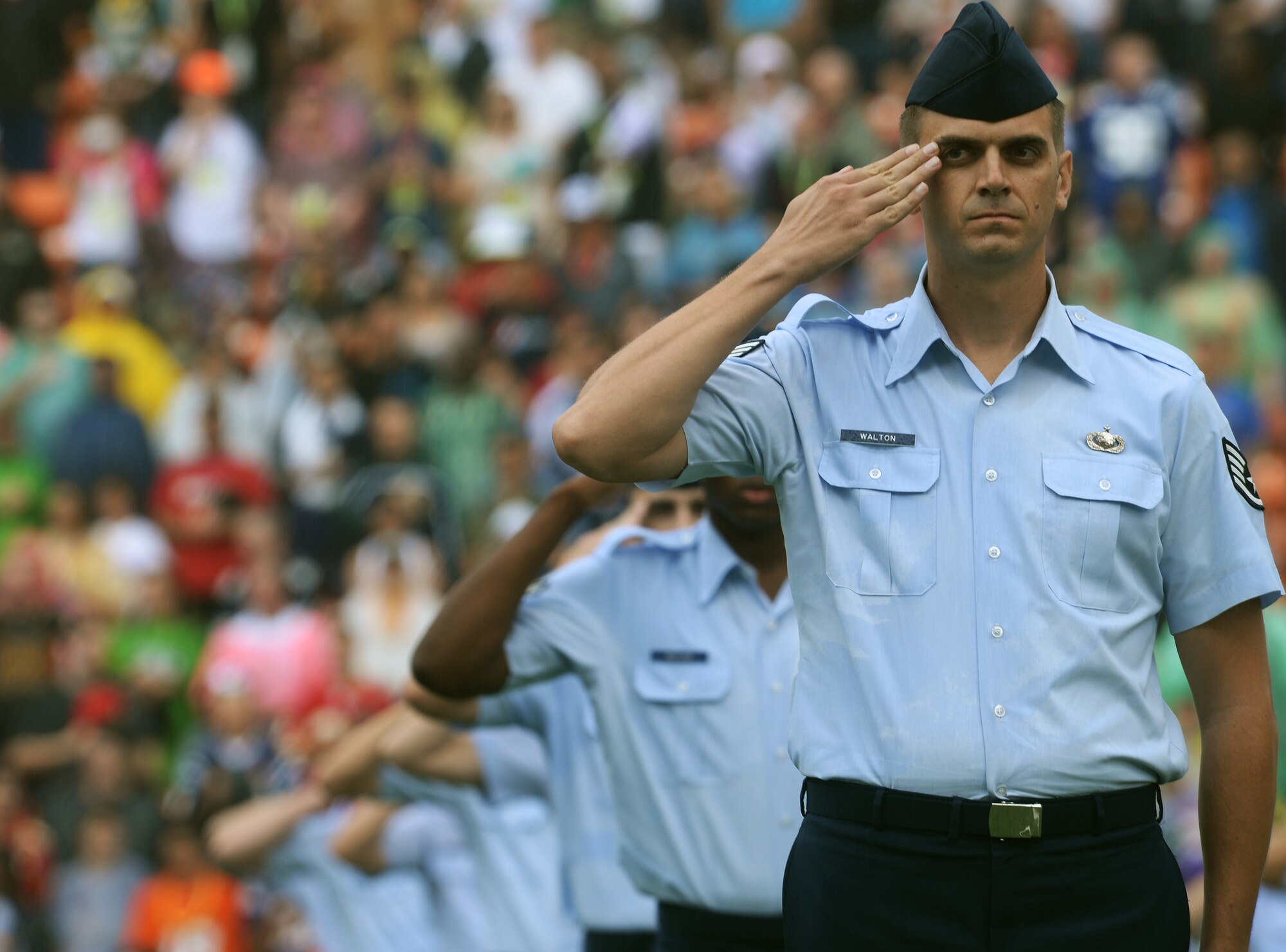 Staff Sgt. Benjamin Walton, 324th Intelligence Squadron, salutes during the singing of The Star-Spangled Banner during the 2014 Pro Bowl at Aloha Stadium in Honolulu, Hawaii, Jan. 26, 2014. Hundreds of service members from the U.S. Air Force, Army, Marine Corps and Navy lined up in formation on the field to participate in the national anthem presentation. (U.S. Air Force photo/Staff Sgt. Alexander Martinez)