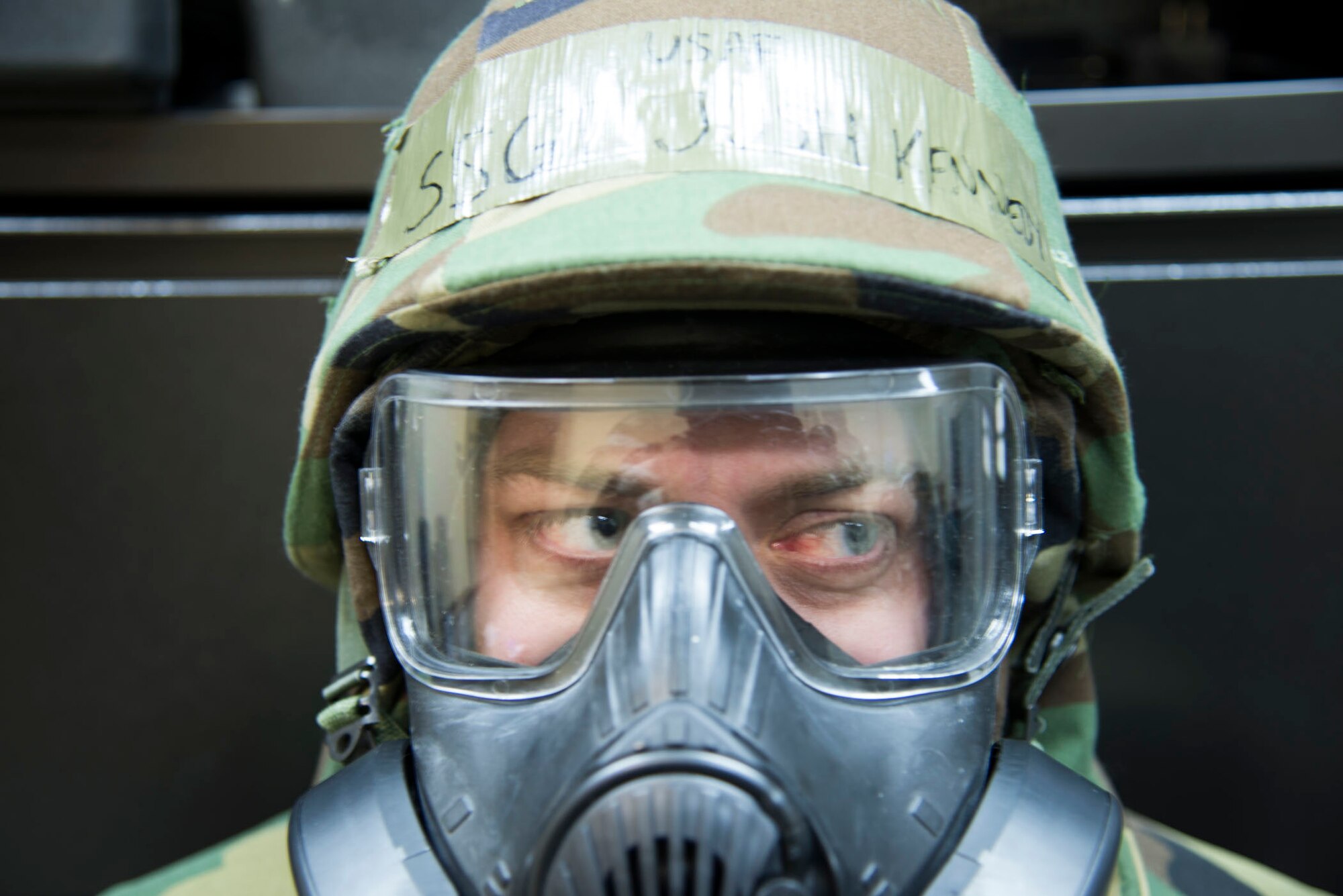 Staff Sgt. Joshua Kennedy from the 35th Fighter Wing legal office waits to hear his zone is clear during Phase II of an operational readiness exercise at Misawa Air Base, Japan, Jan. 27, 2014.  Kennedy donned his mask after a simulated attack where chemicals may have been used.  (U.S. Air Force photo/ Tech. Sgt. Araceli Alarcon)