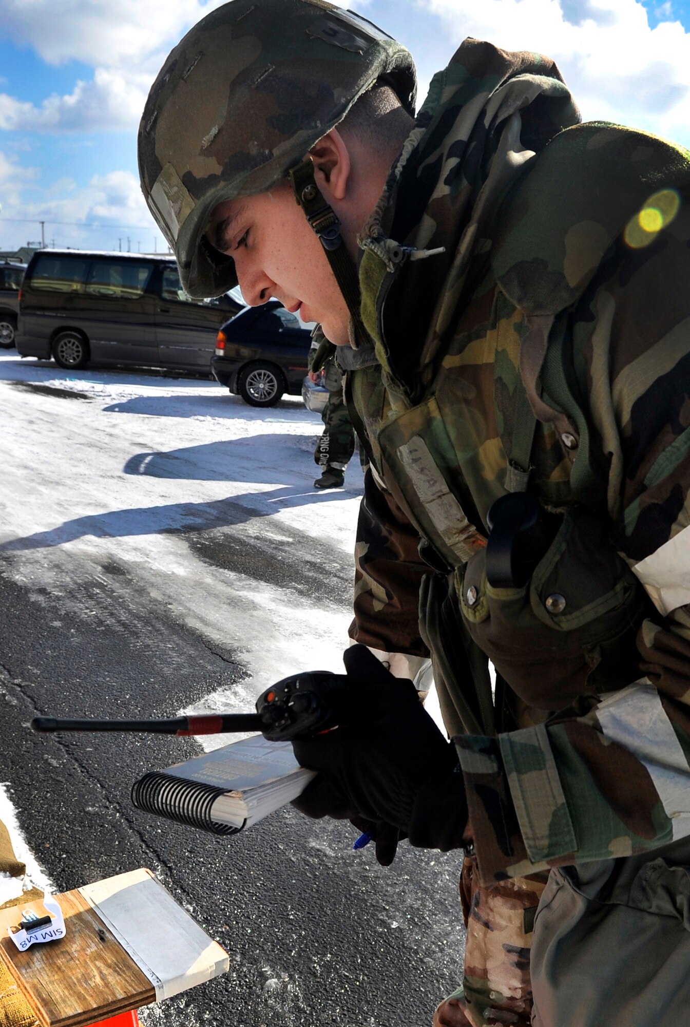 Airman 1st Class Martin Dominguez, 35th Fighter Wing judge advocate paralegal, checks a stanchion for signs of a simulated chemical attack during a post attack reconnaissance sweep at Misawa Air Base, Japan, Jan. 27, 2014. Airmen here are participating in an operational readiness exercise, which tests their ability to operate in a simulated combat environment. (U.S. Air Force photo by Airman 1st Class Zachary Kee)