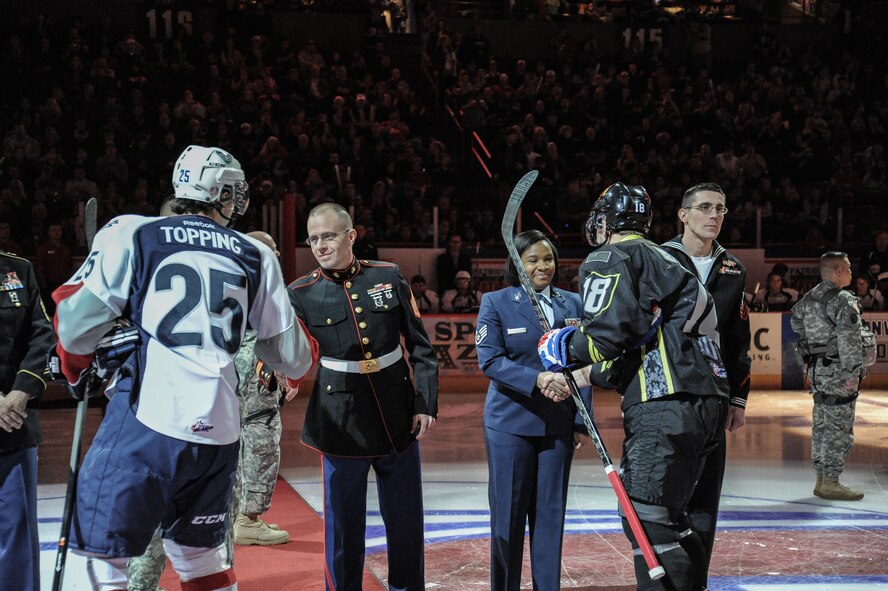 The Tri-City Americans’ Mitch Topping (left) and The Spokane Chiefs’ Reid Gow (right) greet U.S. Marine Staff Sergeant Eric Nelson and U.S. Air Force Staff Sgt. Jasmine Phillips in the opening ceremony during the Spokane Chiefs Military Appreciation Night Jan. 26, at Spokane, Wash.  The Spokane Chiefs hosted the Tri-City Americans at Spokane Arena as part of their Military Appreciation Night to honor members of the U.S. Armed Forces and thanked them for their service. (U.S. Air Force photo by Staff Sgt. Alexandre Montes/RELEASED)