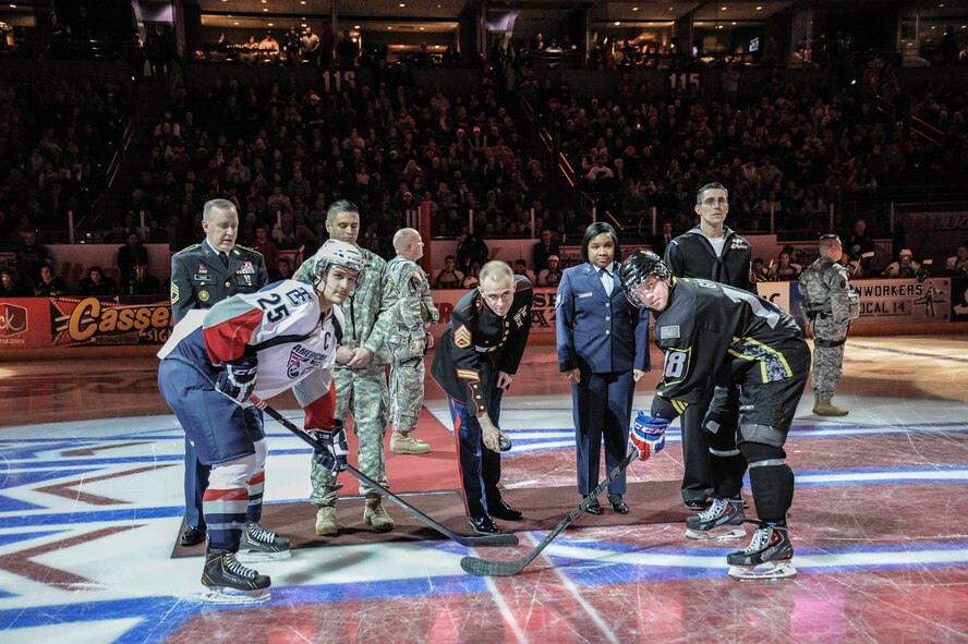 U.S. Marine Staff Sergeant Eric Nelson drops the first puck of the game as part of the opening ceremony during the Spokane Chiefs Military Appreciation Night Jan. 26, at Spokane, Wash. The Spokane Chiefs hosted the Tri-City Americans at Spokane Arena as part of their Military Appreciation Night to honor members of the U.S. Armed Forces and thanked them for their service. (U.S. Air Force photo by Staff Sgt. Alexandre Montes/RELEASED)