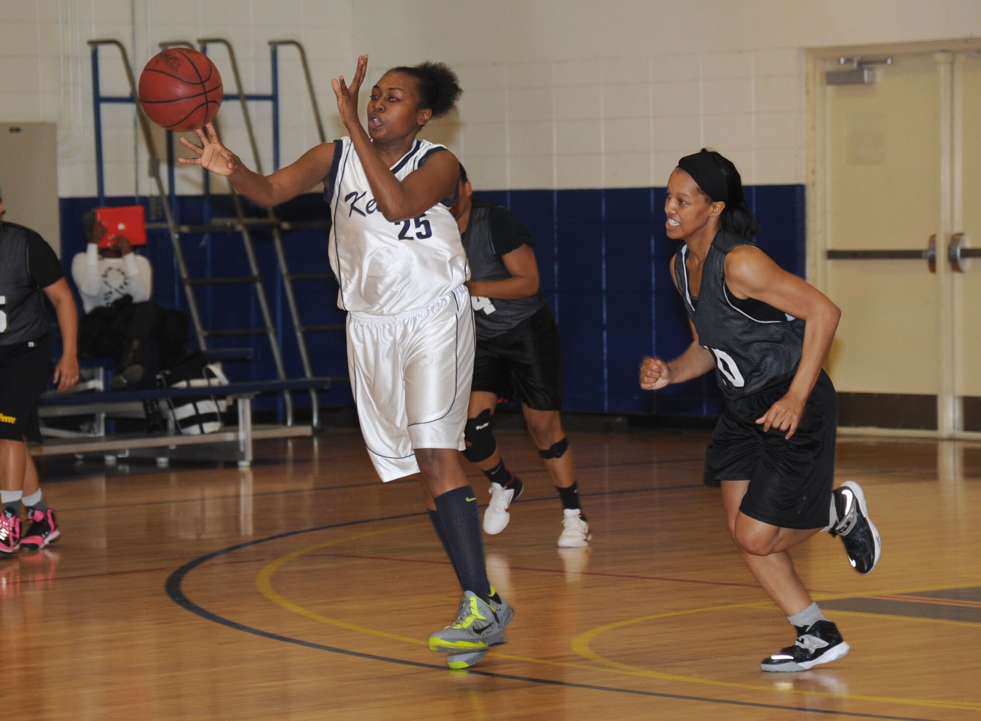 Tamekia Foley, Keesler, passes the ball forward to a teammate as Benita Kurtz, Fort Gordon closes in behind her during a women’s varsity basketball game Jan. 25, 2014, Keesler Air Force Base, Miss. Keesler defeated Fort Gordon, 70-37. The men’s team lost to Fort Gordon, 78-88.  (U.S. Air Force photo by Kemberly Groue)