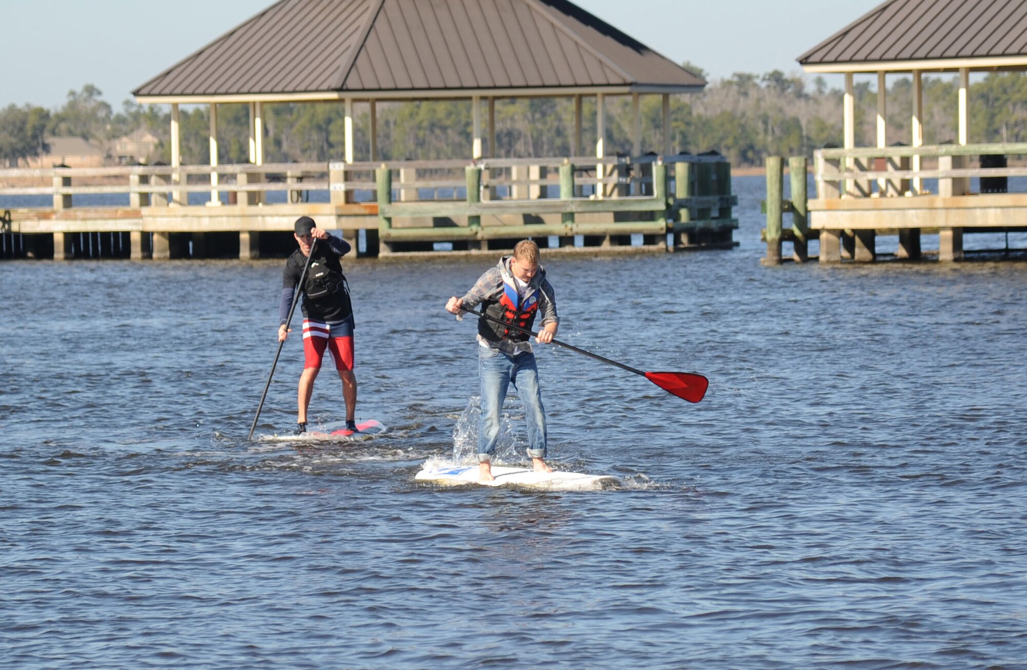 Peter Otten, Keesler Center For Naval Aviation Technical Training Unit, and Gerad Lee, 81st Diagnostic and Therapeutics Squadron, paddle their way to the finish line on paddle boards during the 2nd annual polar bear regatta Jan. 25, 2014, at Marina Park, Keesler Air Force Base, Miss.  The event was sponsored by outdoor recreation.  (U.S. Air Force photo by Kemberly Groue)