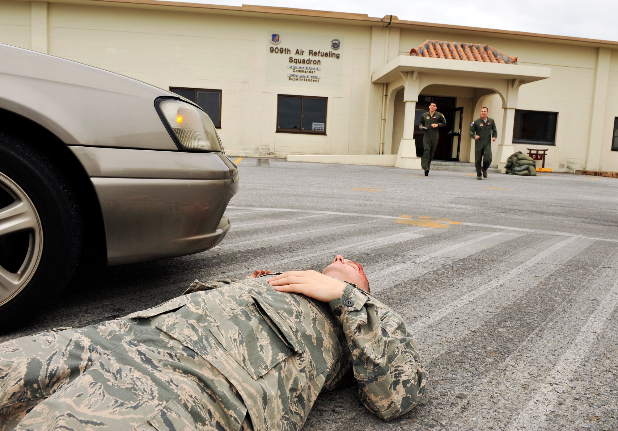 Members from the 909th Air Refueling Squadron run toward a simulated patient during a Mission Focused Exercise scenario on Kadena Air Base, Japan, Jan. 27, 2014. MFEs give Airmen the opportunity to train in a safe environment and prepare for real world contingencies. (U.S. Air Force photo by Naoto Anazawa)