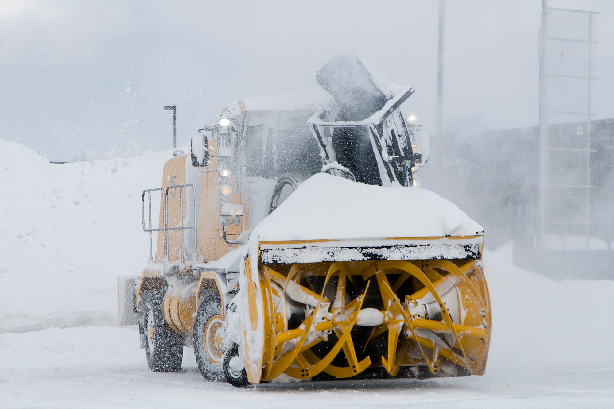 Dave Smith, a civilian contractor, uses an industrial snow blower to remove snow from an airfield at Grissom Air Reserve Base, Ind., Jan. 25, 2014. Grissom's snow-control team has cleared more than 30 inches of snow that have fallen on the base's flightline this month. (U.S. Air Force photo/Staff Sgt. Andrew McLaughlin)
