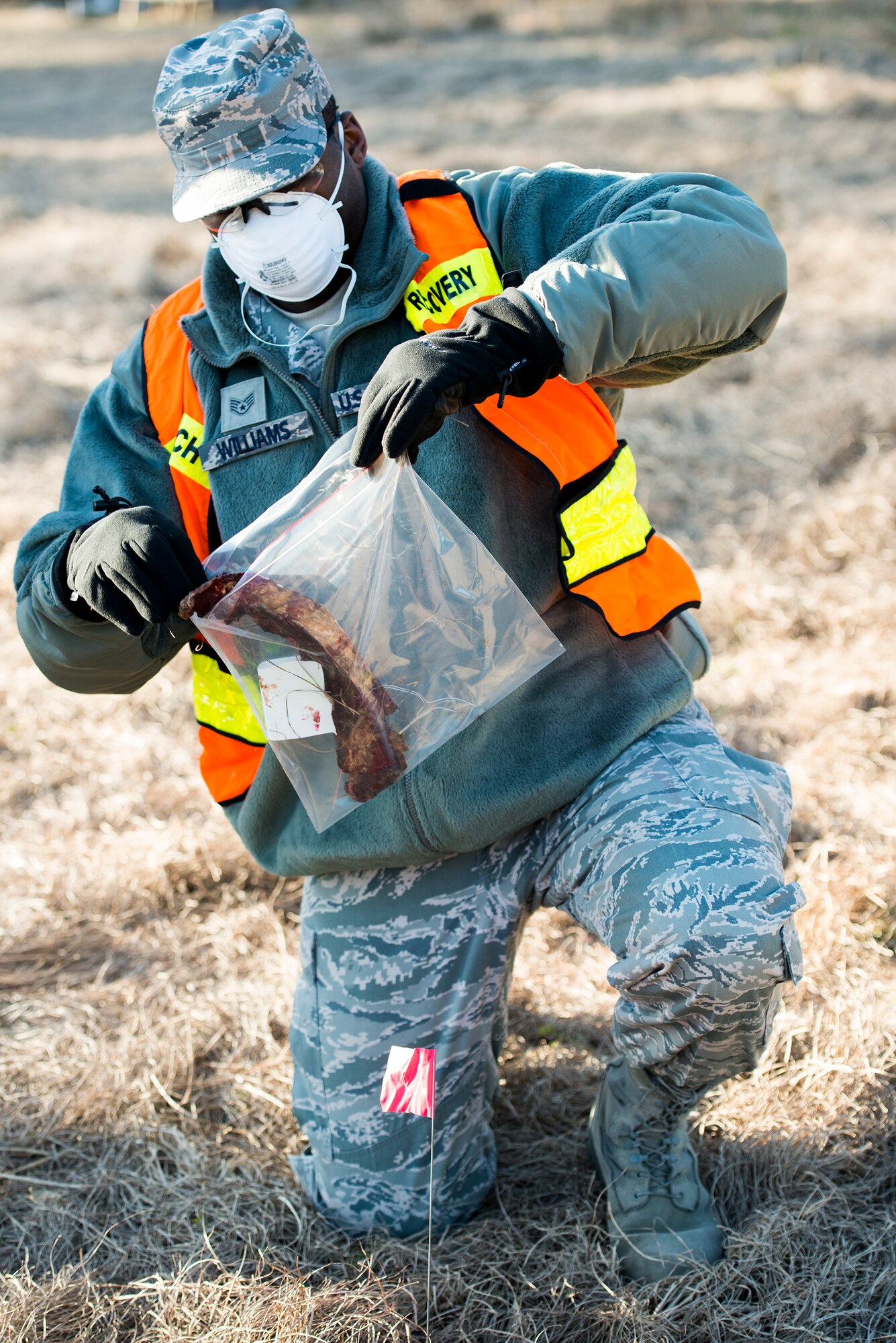 U.S. Air Force Staff Sgt. Blake Williams, 23d Force Support Squadron food service accountant, bags simulated human remains after a simulated aircraft accident during a SART exercise at Moody Air Force Base, Ga., Jan. 24, 2014. Williams served as the line team flanker on Moody’s search and recovery team. (U.S. Air Force photo by Airman 1st Class Ryan Callaghan/Released)
