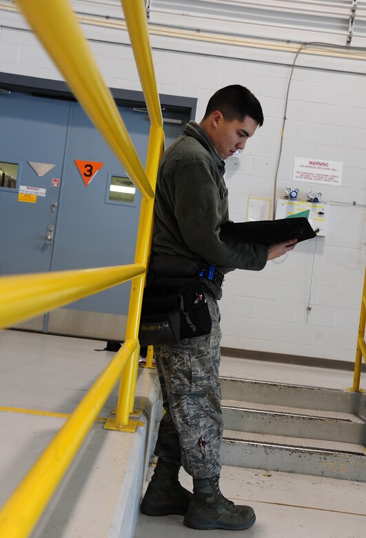 Airman 1st Class Cameron Wheatley, 442nd Fighter Wing Aircraft Maintenance Squadron aircraft armament technician, reviews aircraft forms at Whiteman Air Force Base, Mo., Dec. 17, 2013. The forms are a record of documentation on maintenance and load operations on the A-10 Thunderbolt II. (U.S. Air Force photo by Staff Sgt. Nick Wilson/Released)