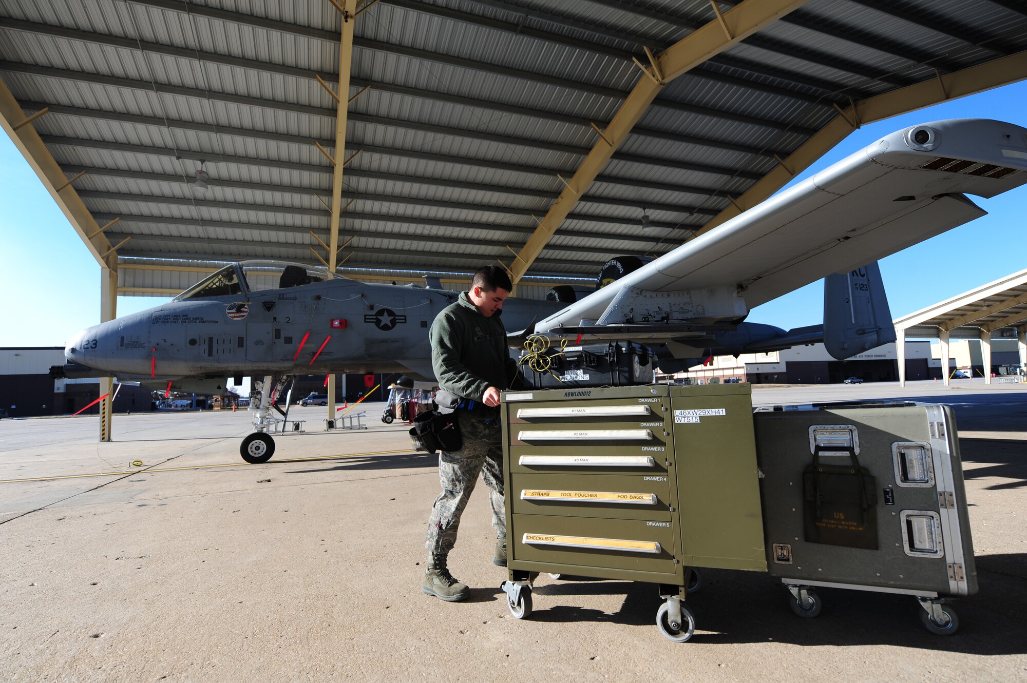 Airman 1st Class Cameron Wheatley, 442nd Fighter Wing Aircraft Maintenance Squadron aircraft armament technician, pushes a 500-pound toolbox to an A-10 at Whiteman Air Force Base, Mo., Dec. 17, 2013. Wheatley and other armament technicians from the 442nd AMXS weapons flight are responsible for maintaining the weapons and ammunition loading systems that allow A-10s to put bombs on target. (U.S. Air Force photo by Staff Sgt. Nick Wilson/Released)