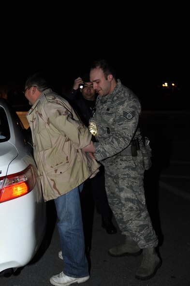 U.S. Air Force Staff Sgt. Jason Torche, 18th Security Forces Squadron response force leader, cuffs an alleged suspect during a Mission Focused Exercise scenario on Kadena Air Base, Japan, Jan. 28, 2014. MFEs are used to prepare and test mission capabilities of airmen across the base for future real-world contingencies. (U.S. Air Force photo by Senior Airman Malia Jenkins)