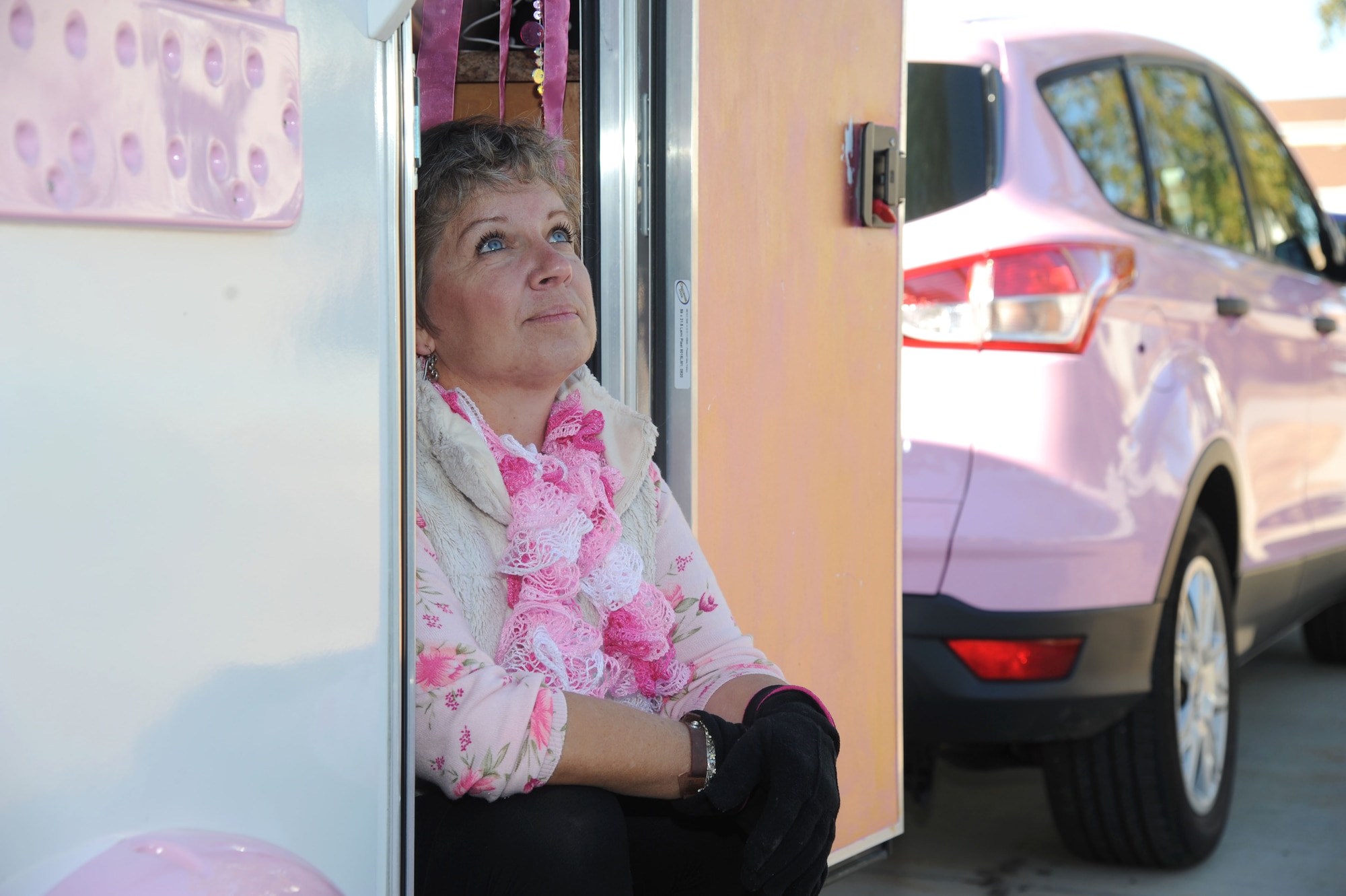 Alison Miller, widow of retired Master Sgt. Chuck Dearing, sits in the doorway of her pink painted teardrop trailer during a travel break Jan. 16, 2014, at the Keesler Air Force Base camp site, Biloxi, Miss.  Following Dearing’s retirement, the couple sold their home and belongings and traveled the country for four years staying primarily in base lodgings. Prior to the death of her husband, Miller told him that her intent was to continue traveling in a pink painted car so that he could find her while out on the road.  (U.S. Air Force photo by Kemberly Groue)