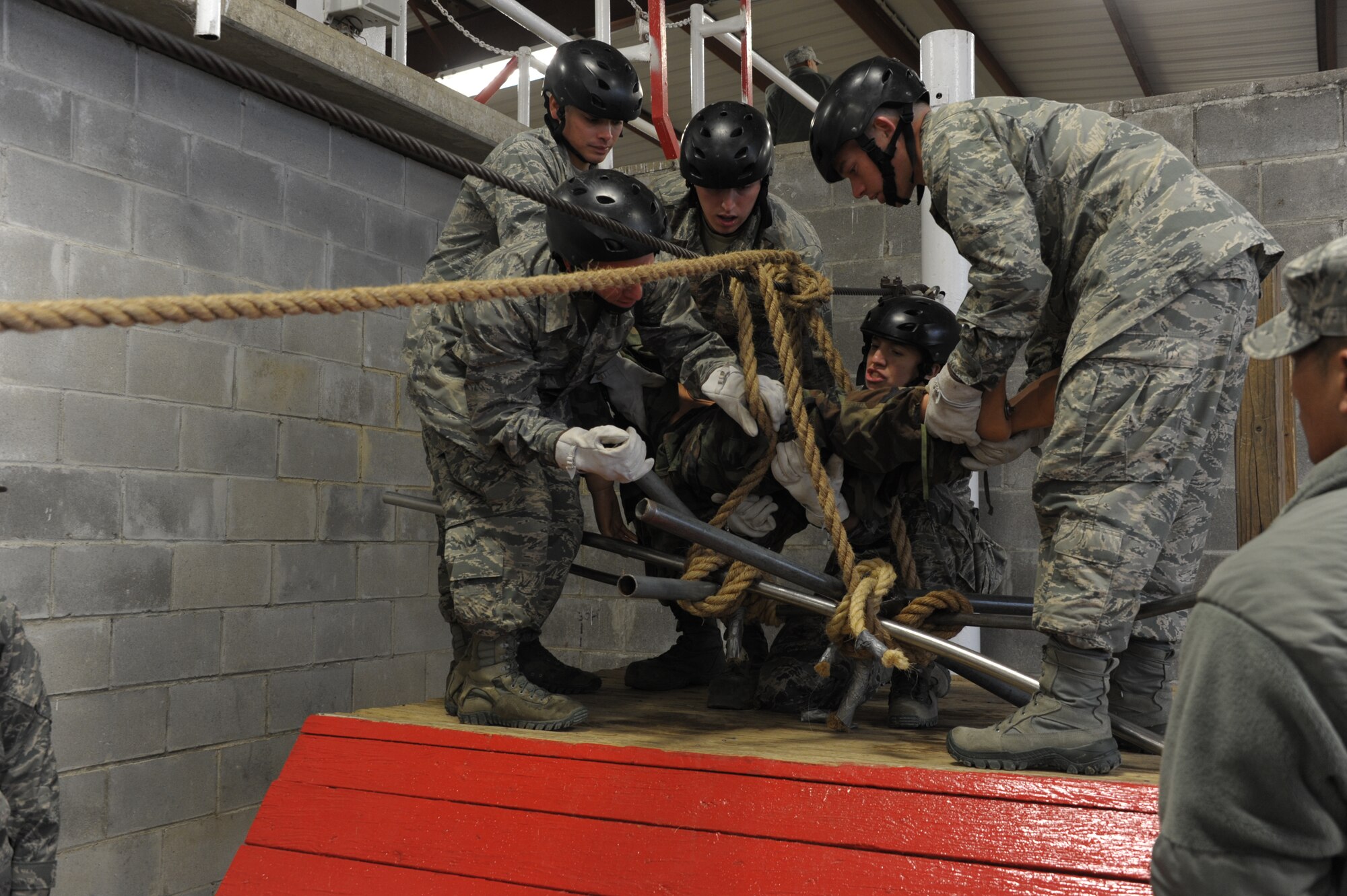 Officer trainees work as a team to overcome an obstacle at the newly refurbished Project X leadership reaction course on Maxwell Air Force Base. Volunteers from the faculty and staff of the Squadron Officer College, which owns the course, dedicated a Saturday to repainting and maintenance work to ensure the course remains an effective training tool.(U.S. Air Force Photo by Staff Sgt. Gregory Brook)