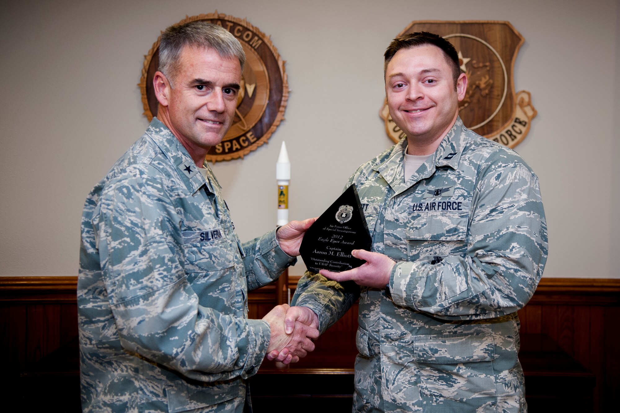 VANDENBERG AIR FORCE BASE, Calif. -- Brig. Gen. Jay Silveria, 14th Air Force vice commander, congratulates Capt. Aaron M. Elliott, 614th Air and Space Operations Center force enhancement duty officer, upon Elliotts’s acceptance of the Air Force Office of Special Investigations Eagle Eyes Award Jan. 24, 2014. The award recognizes Elliott for his outstanding contribution to the Air Force’s terrorism and force protection initiative. (U.S. Air Force Photo/Airman 1st Class Yvonne Morales)