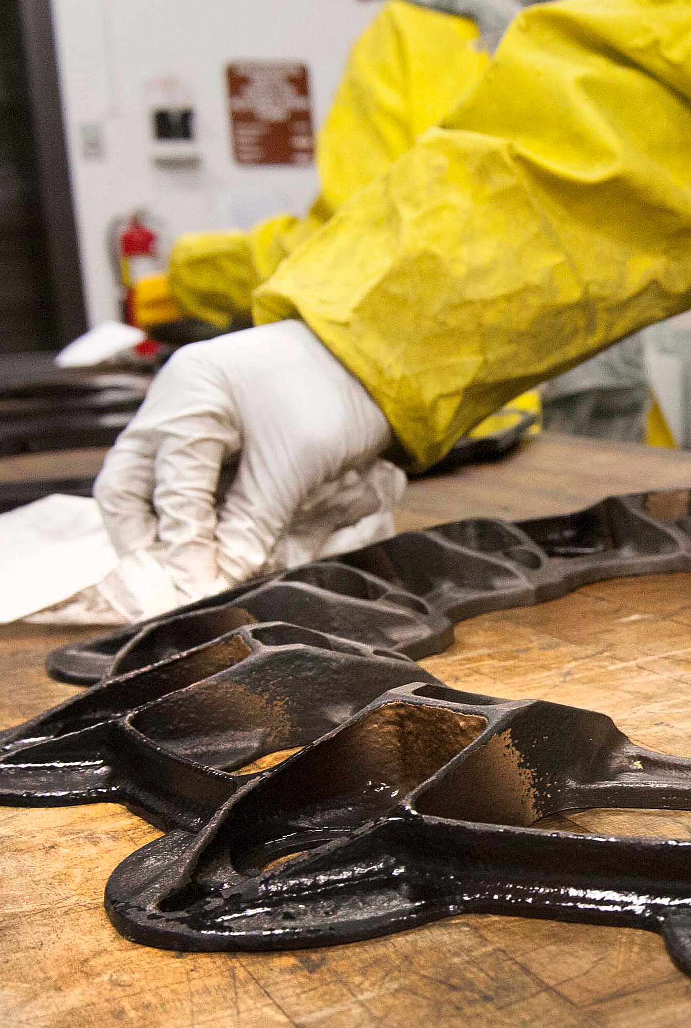 Fluorescent magnetic particles are removed from the plate backing of brake pads for a B-52H Stratofortress during a Magnetic Particle inspection at Minot Air Force Base, N.D., Jan. 21, 2014. If the particles are not removed, they may be harmful to the part when subject to further use. (U.S. Air Force photo/Senior Airman Stephanie Sauberan)   