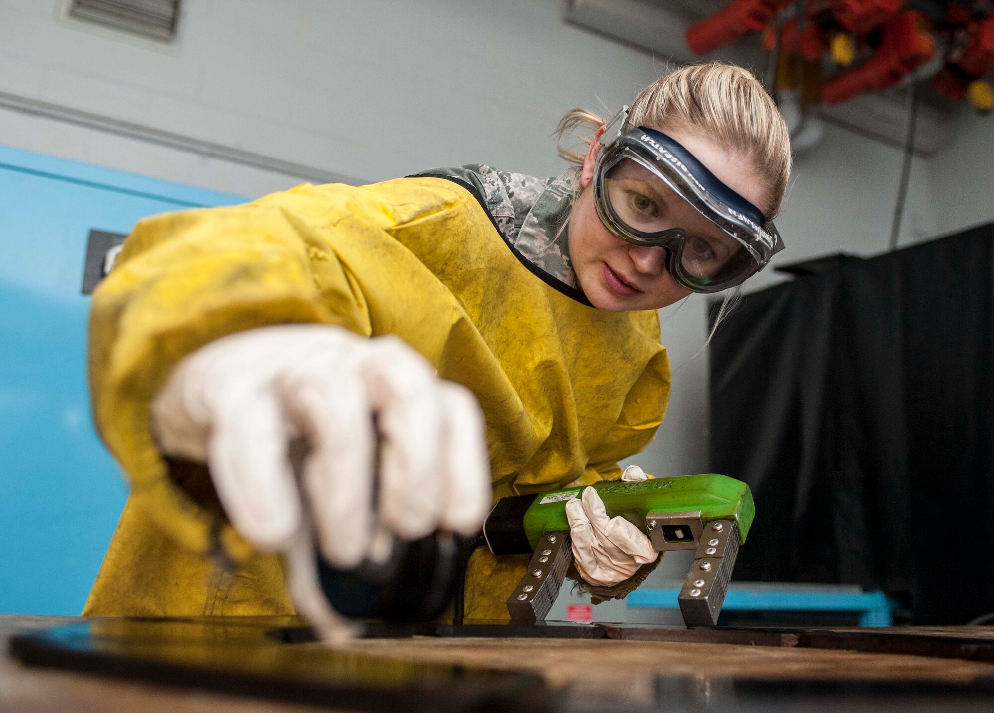 Airman 1st Class Courtney Harrah, 5th Maintenance Group non-destructive inspection apprentice, checks the brake pads of a B-52H Stratofortress with a field indicator, during a Magnetic Particle inspection, to ensure they have been properly demagnetized at Minot Air Force Base, N.D., Jan. 21, 2014. To demagnetize the part, a parker probe is placed on an alternating current and then energized while the inspector pulls the magnet away from the part.  This will reduce the magnetic field in the part to near zero. (U.S. Air Force photo/Senior Airman Stephanie Sauberan)
