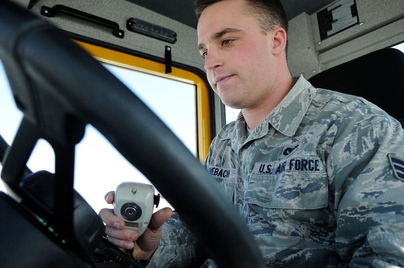 Senior Airman Scott Steinebach communicates over the radio with fellow equipment operators at Joint Base Andrews, Md., Jan. 23, 2014. Steinebach plows snow on the flight line to execute the 11th Civil Engineer Squadron primary mission of keeping the airfield safe and operable. Steinebach is a pavement and equipment operator. (U.S. Air Force photo / Airman 1st Class Nesha Humes)