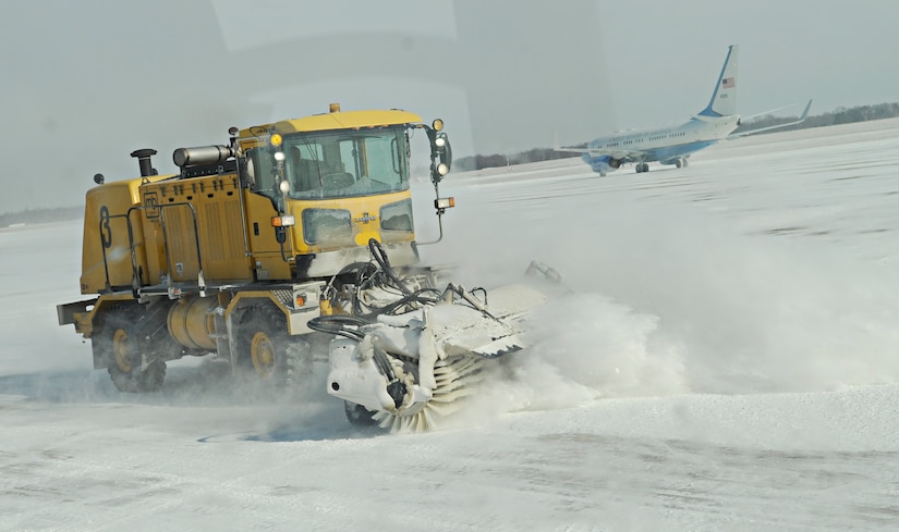 11th Civil Engineer Squadron equipment operators sweep snow on the flight line at Joint Base Andrews, Md., Jan. 23, 2014. As colder temperatures surround the installation, team members remain on-call and ready to assemble within moments. Nights before forecasted flurries, personnel arrive to work hours before precipitation hits, standing ready to move as soon as the first flake falls. (U.S. Air Force photo / Airman 1st Class Nesha Humes)