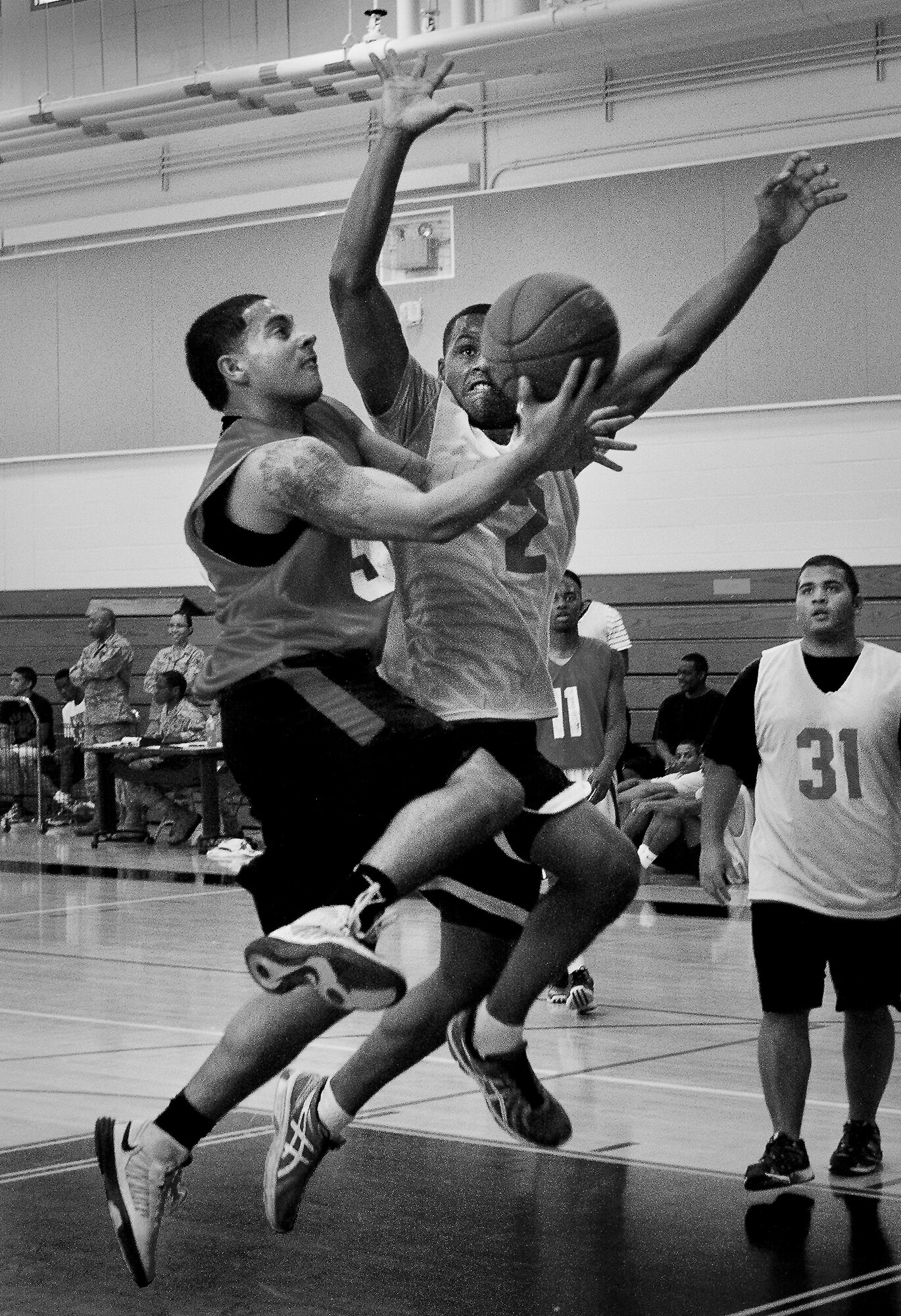 A player soars to the basket as a defender tries to block during a 3-on-3 basketball tournament held Jan. 24 at the Eglin Air Force Base, Fla., gym.  A total of six teams battled it out in 10-minute games in the double elimination tournament.  (U.S. Air Force photo/Samuel King Jr.)