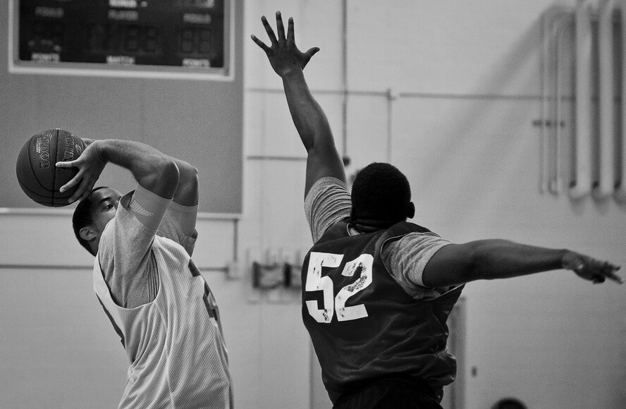 A player shoots a three-pointer over a defender during a 3-on-3 basketball tournament held Jan. 24 at the Eglin Air Force Base, Fla., gym.  A total of six teams battled it out in 10-minute games in the double elimination tournament.  (U.S. Air Force photo/Samuel King Jr.)